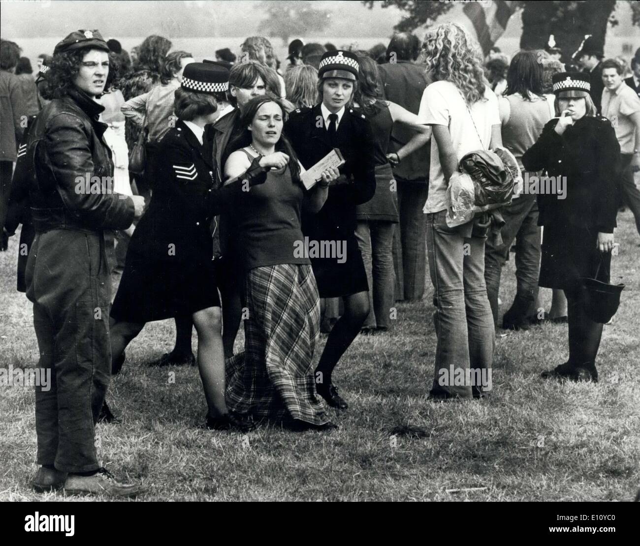 Aug. 30, 1974 - 600 Police Clash With Pop Fans In A ''Clear Out'' Raid At Windsor Great Park: More than 600 police swooped on 2,000 hippies at the Windsor Great Park pop festival and ordered them to ''pack up their tents and go''. Some obeyed the order, but many of them resisted. A scene of hysteria broke out following the clash between the police and the pop fans. Many people were injured, including policemen, and many arrests were made. Photo shows A girl pop fan is escorted away by policewoman, in Windsor Great Park yesterday. Stock Photo