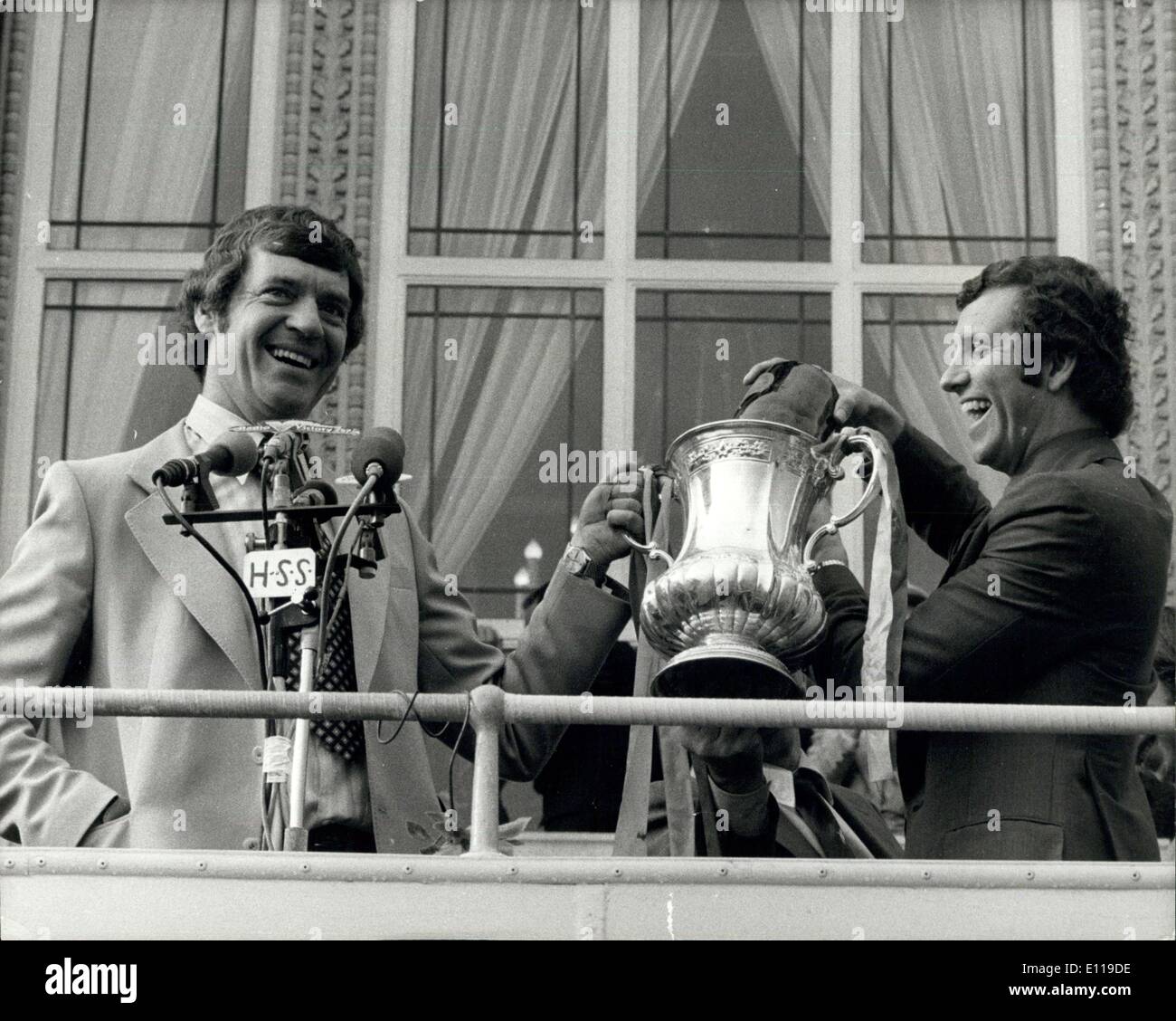 May 03, 1976 - F.A. CUP WINNERS RETURN TO SOUTHAMPTON: F.A. Cup winners, Southampton returned home yesterday to a welcome from ore than 160,000 people. The team were driven around the town in a open top double-Decker bus and at the end of the 19 mile route the Mayor MRS. ELEANOR PUGH gave the team the freedom of the Southampton. Photo shows Manager LAWRIE McMENEMY and player Peter Osgood celebrate the victory with champagne on the balcony of the Guildhall. Stock Photo