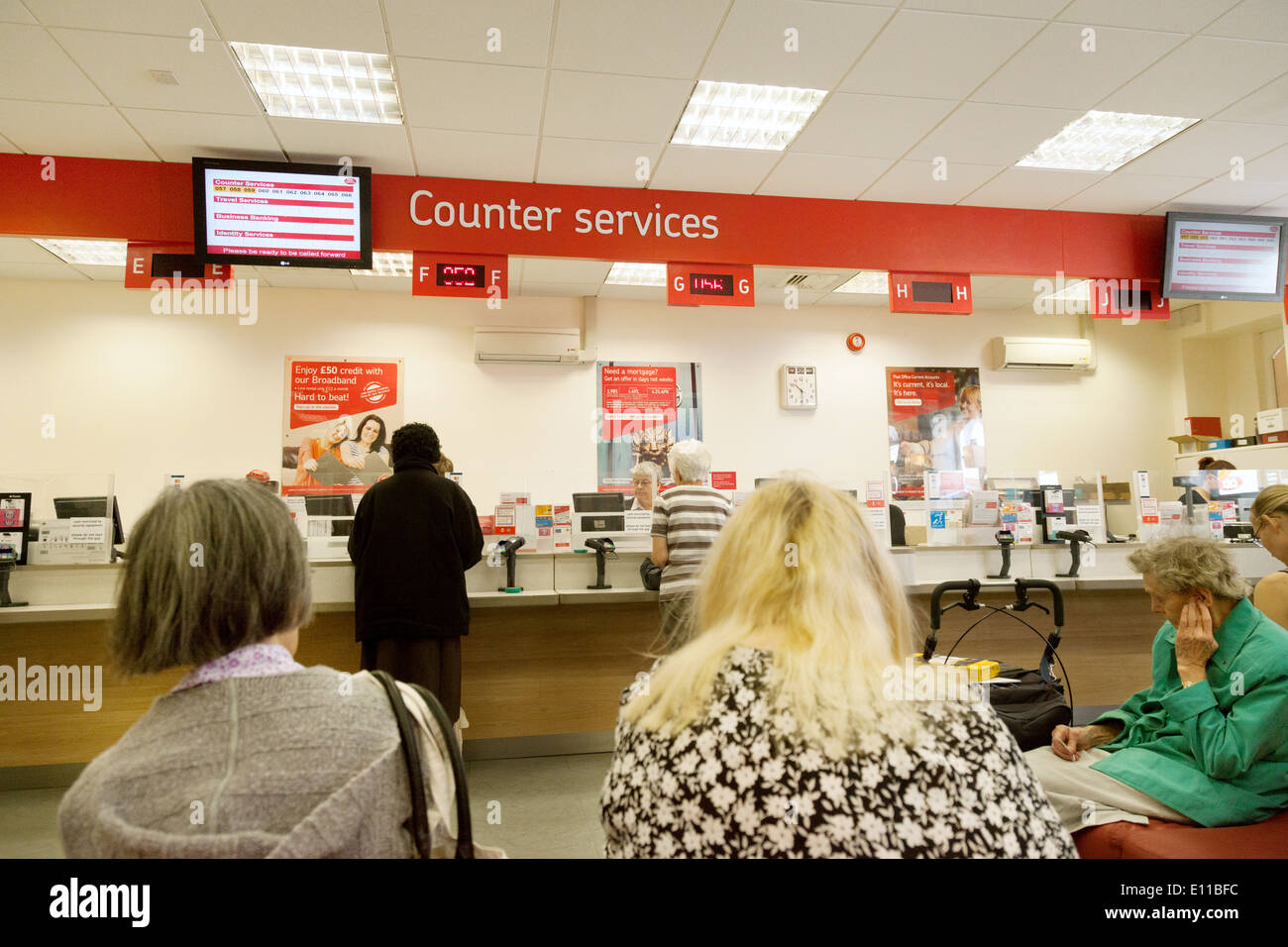 People waiting to be served, the Post Office interior, Cambridge England UK Stock Photo