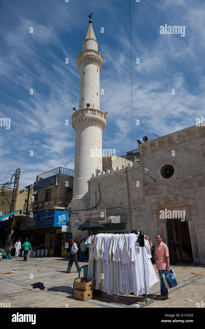 Man shoping for dishdash infront of the minaret of the King Hussein Mosque, Amman, Jordan Stock Photo