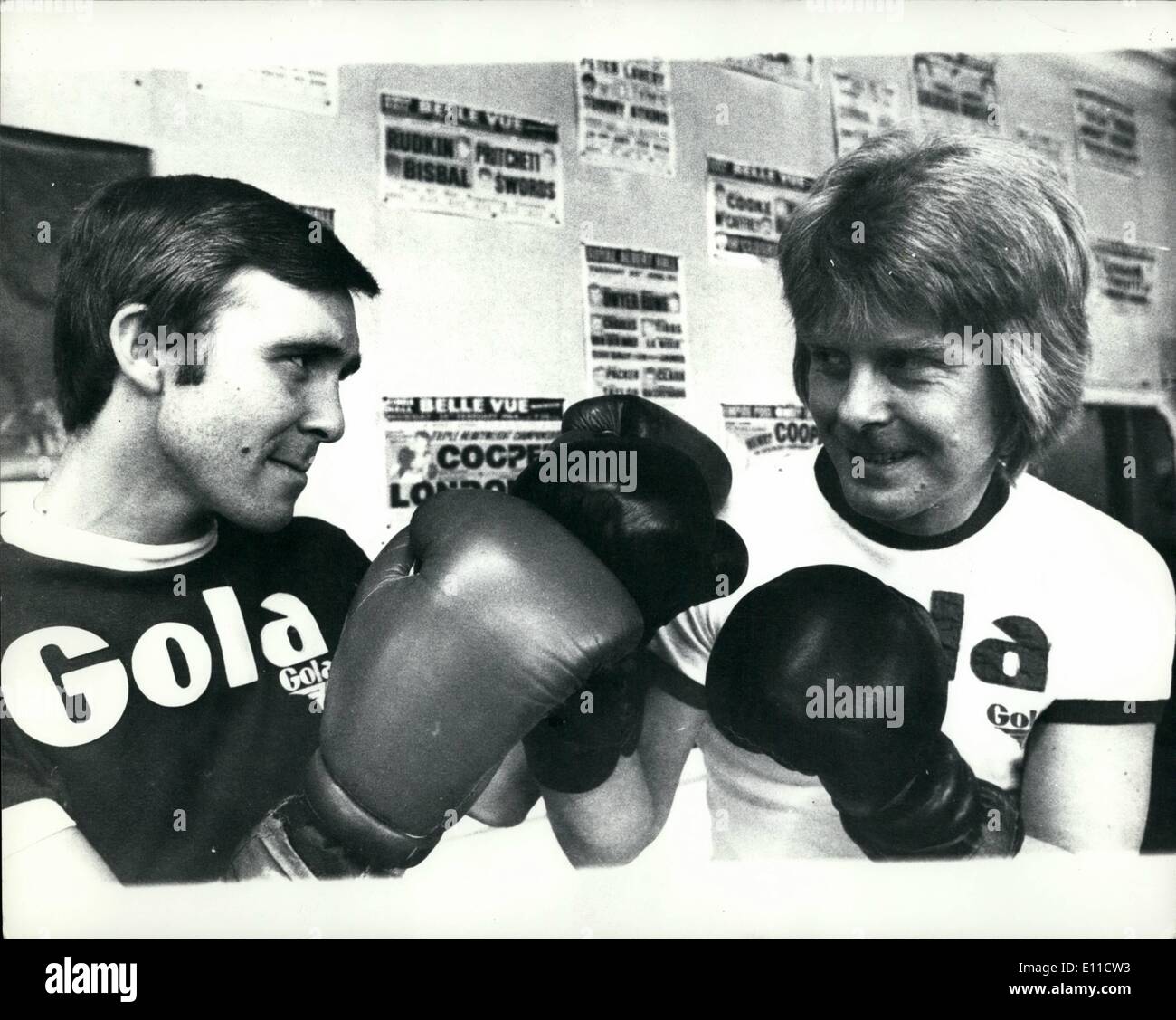 Mar. 03, 1977 - John H. Strachey Gets Ready For His Title Fight With The Help Of Singer Joe Brown: John H. Strachey the former world walterweight champion now in training for his fight against British Champion Dave ''Bot'' Green at Wembley next tuesday, was hard at it at the Royal Oak Gymn Canning Town today with the help of singer Joe Brown who has just released his latest single called ''The Boxer''. Photo shows John H. Strachey left, and Joe Brown shape-up in the gymn during Joe's visit to watch him train. Stock Photo