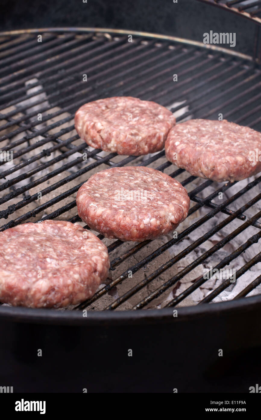 Burgers cooking on a charcoal fired barbecue Stock Photo Alamy