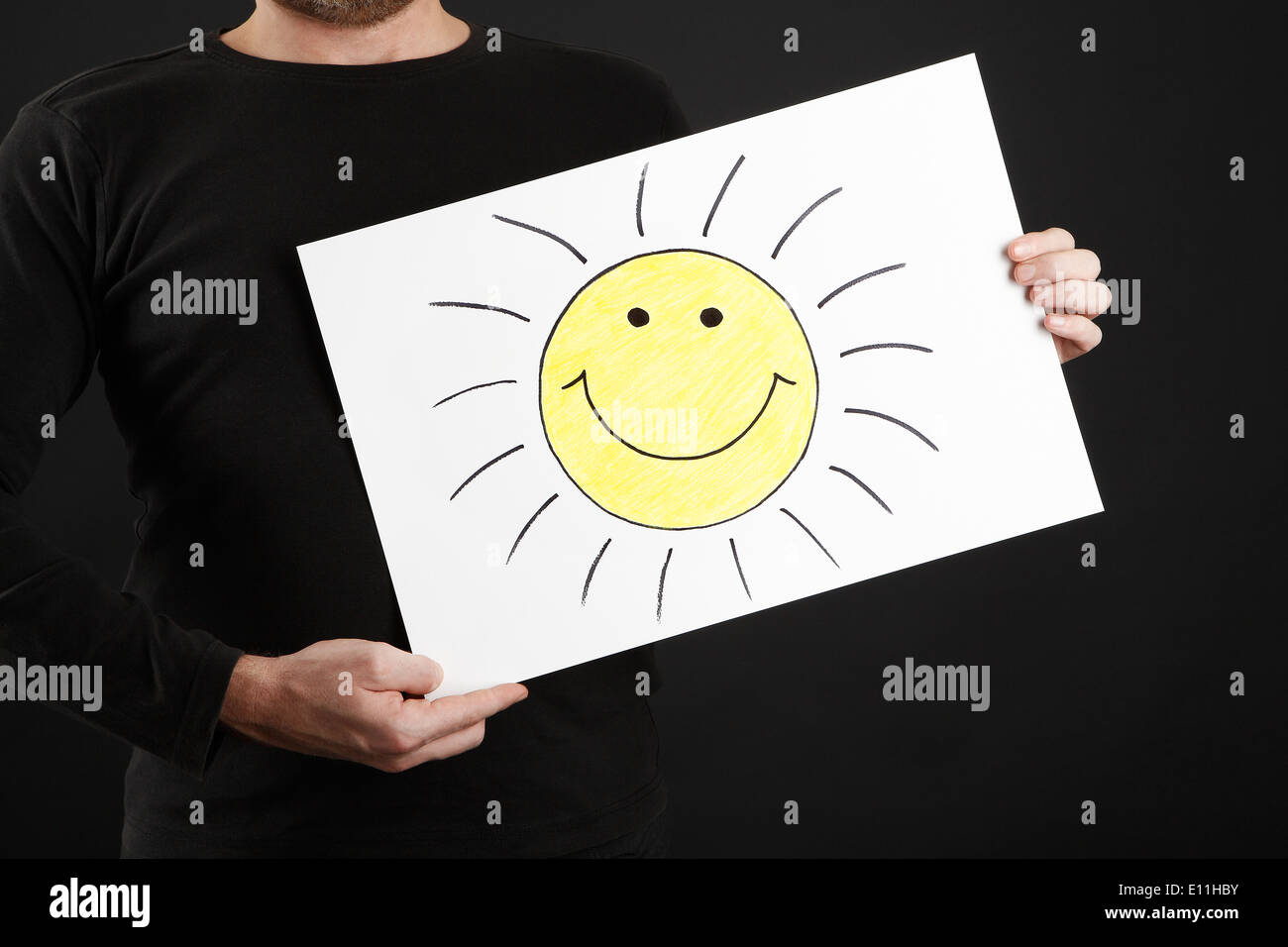 Man in black clothes holding billboard with sun Stock Photo