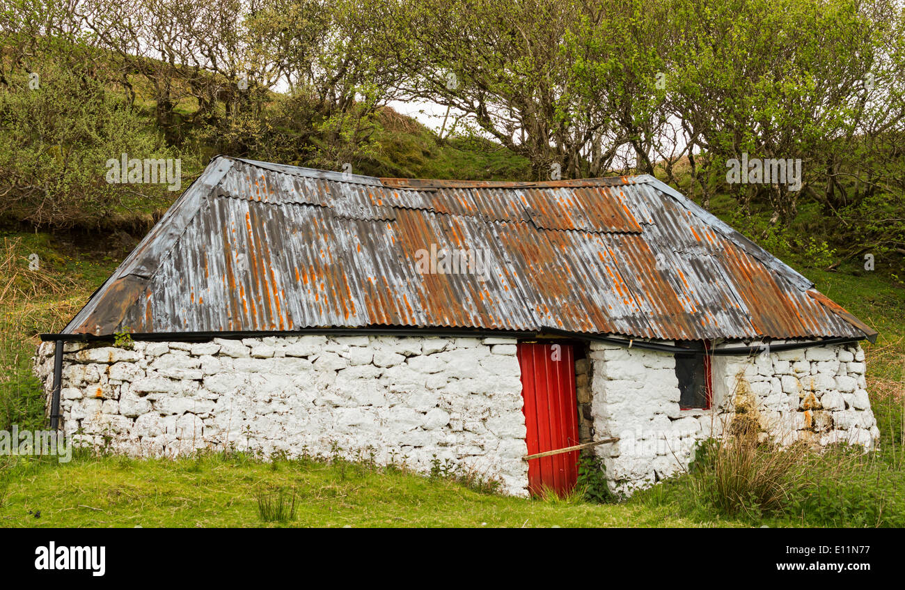 DESERTED CROFT HOUSE WITH A RED DOOR ON THE  ISLE OF SKYE SCOTLAND Stock Photo