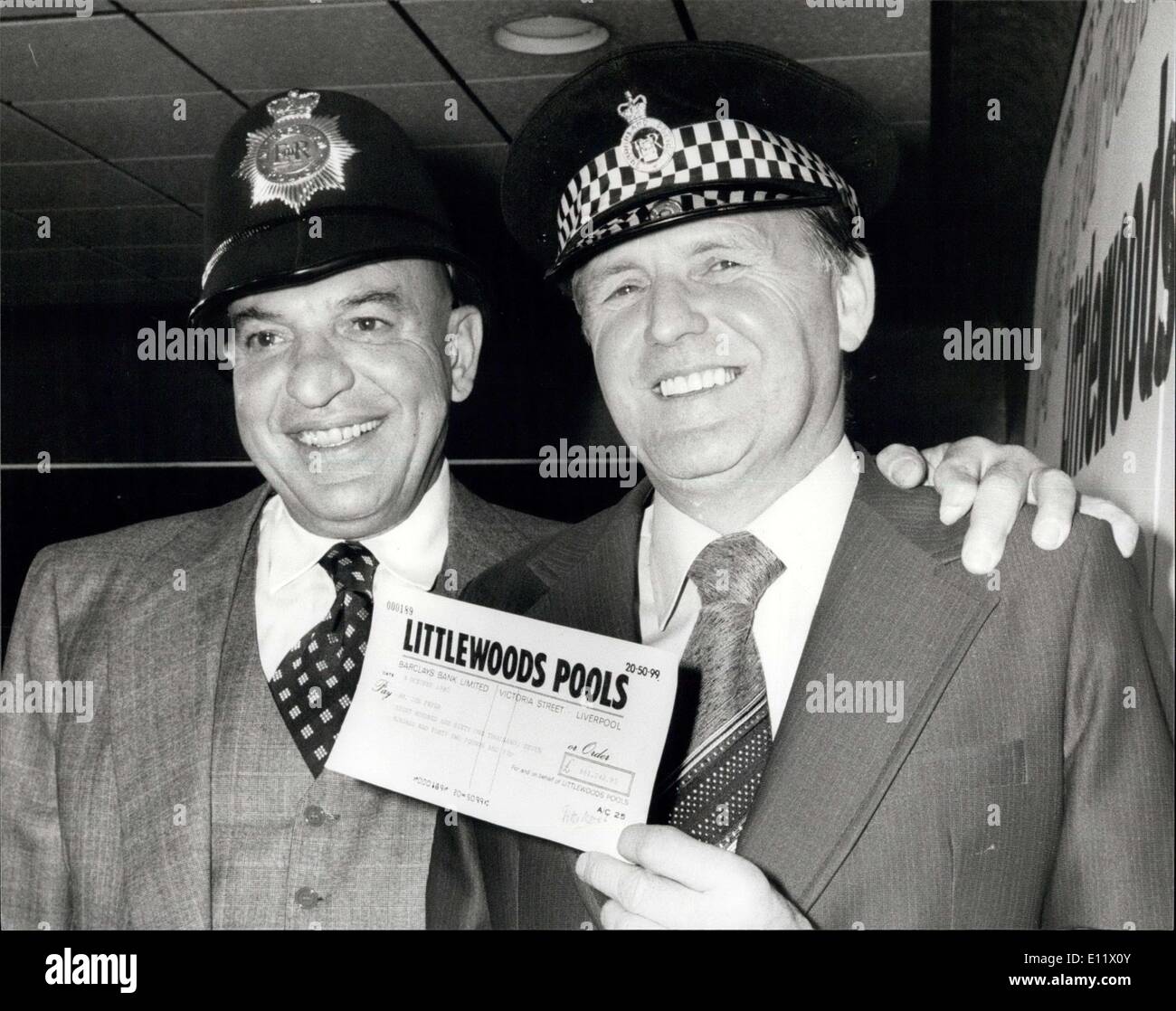 Oct. 06, 1980 - A Fair Cop' Ex-Policeman wins ?881,74,95 on the Pools: Retired Police Sergeant Joe Fryer this week made his best ever 'cop' when in London today he received his reward cheque for ?861,742.95 from the famous American Television 'cop' Telly (Kojak) Savalas. Joe won the top dividend on Littlewood Pools, making him the second biggest winner of all time. Photo shows Telly Savales wearing a London Bobbies helmet with Joe Fryer after presenting the cheque in London today. Stock Photo