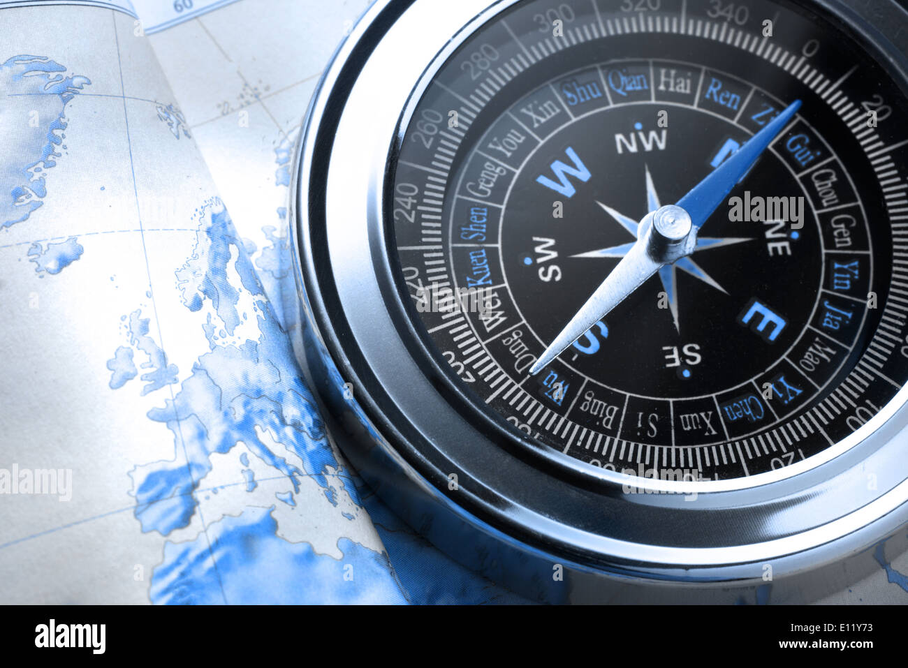 Compass on map background in blue toning Stock Photo
