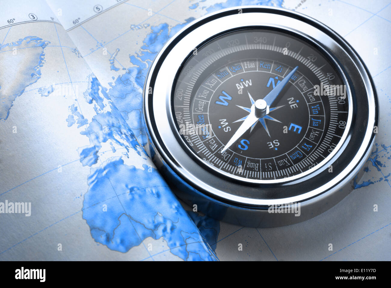 Compass on map background in blue toning Stock Photo