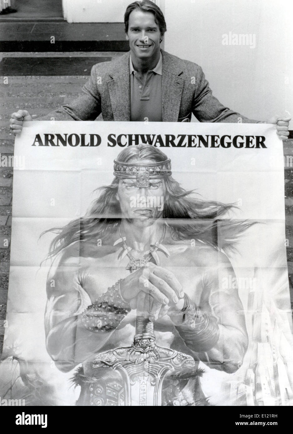 Actor Arnold Schwarzenegger with film poster Stock Photo