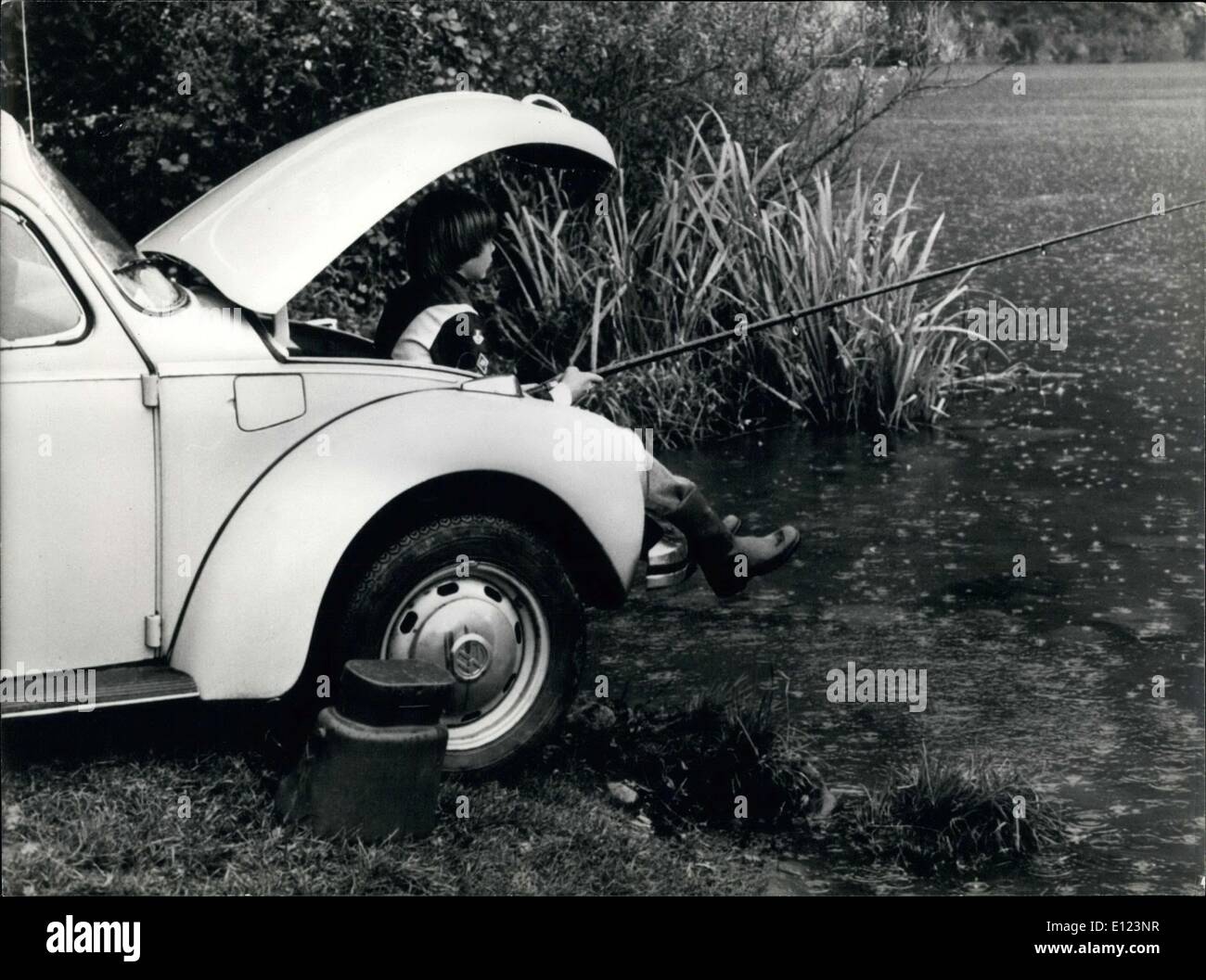 Apr. 24, 1985 Boy Fishes Under Car Hood in Rain, Switzerland Stock