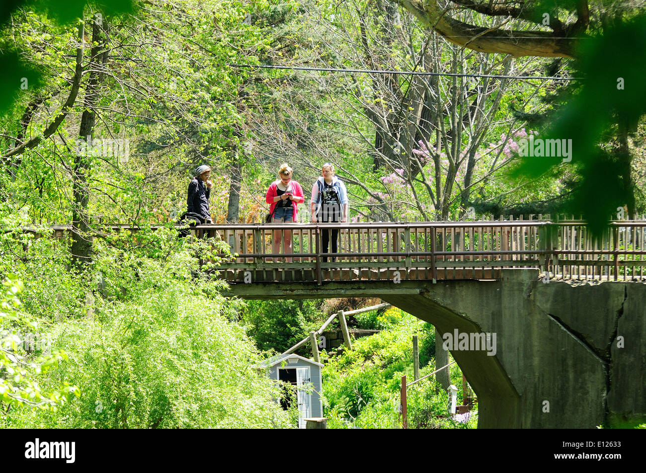 3 People standing on island bridge observing river channel. Stock Photo
