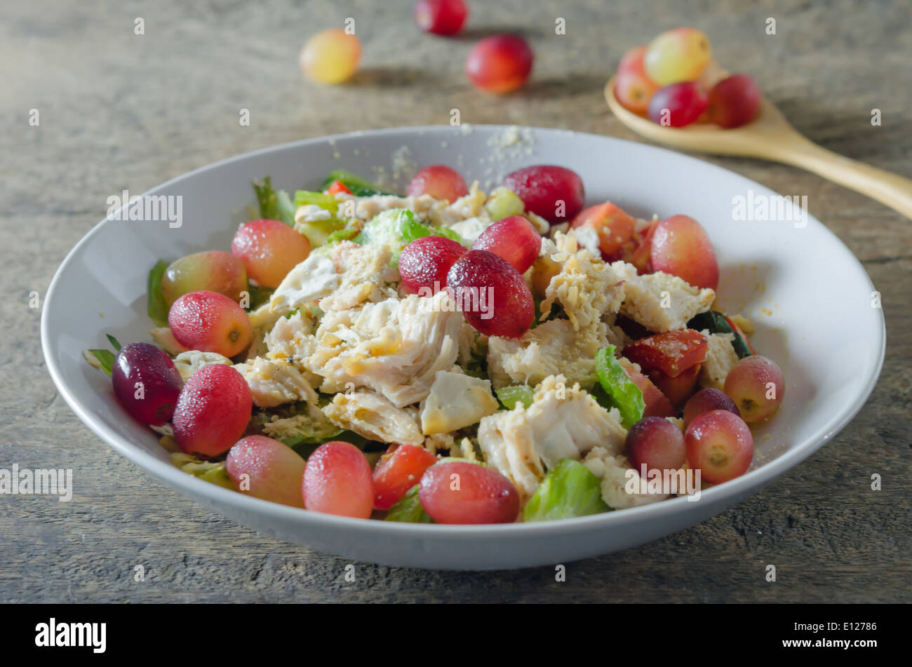 Mix salad with grapes and chicken on white dish Stock Photo