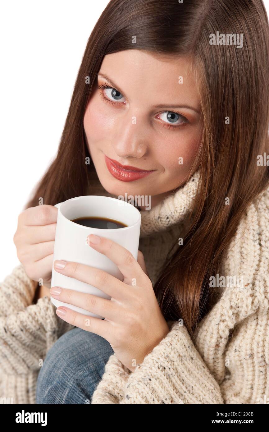 Oct. 29, 2009 - Oct. 29, 2009 - Winter portrait of happy woman holding cup of coffee wearing turtleneck on white Stock Photo