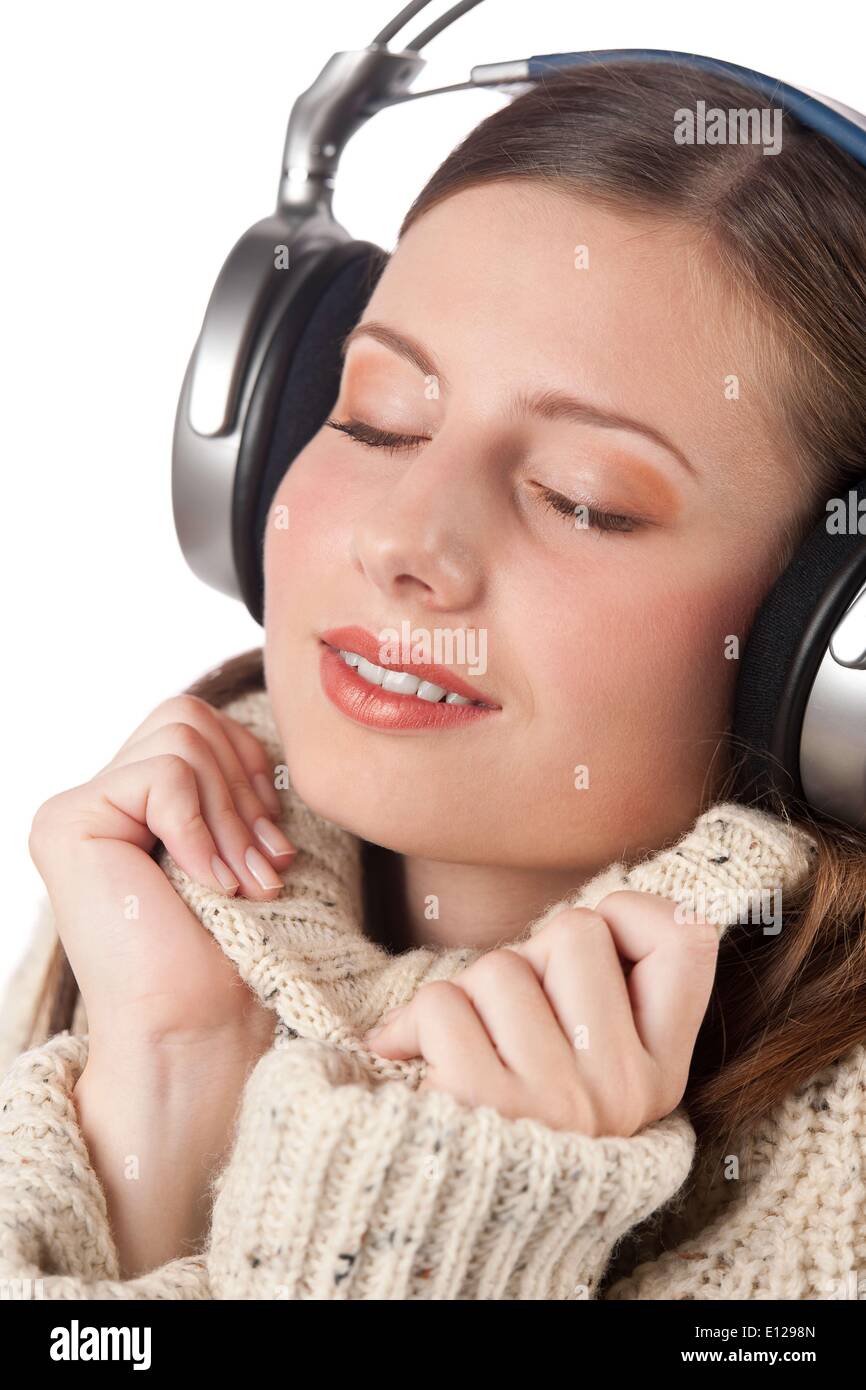 Oct. 29, 2009 - Oct. 29, 2009 - Portrait of happy woman enjoying music with headphones wearing turtleneck on white background (C Stock Photo