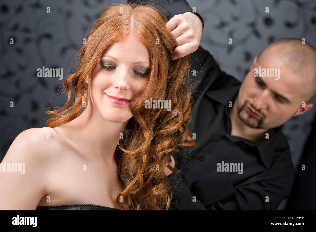 Apr. 07, 2010 - April 7, 2010 - Professional hairdresser with long red curly hair fashion model at luxury salon Ã Stock Photo
