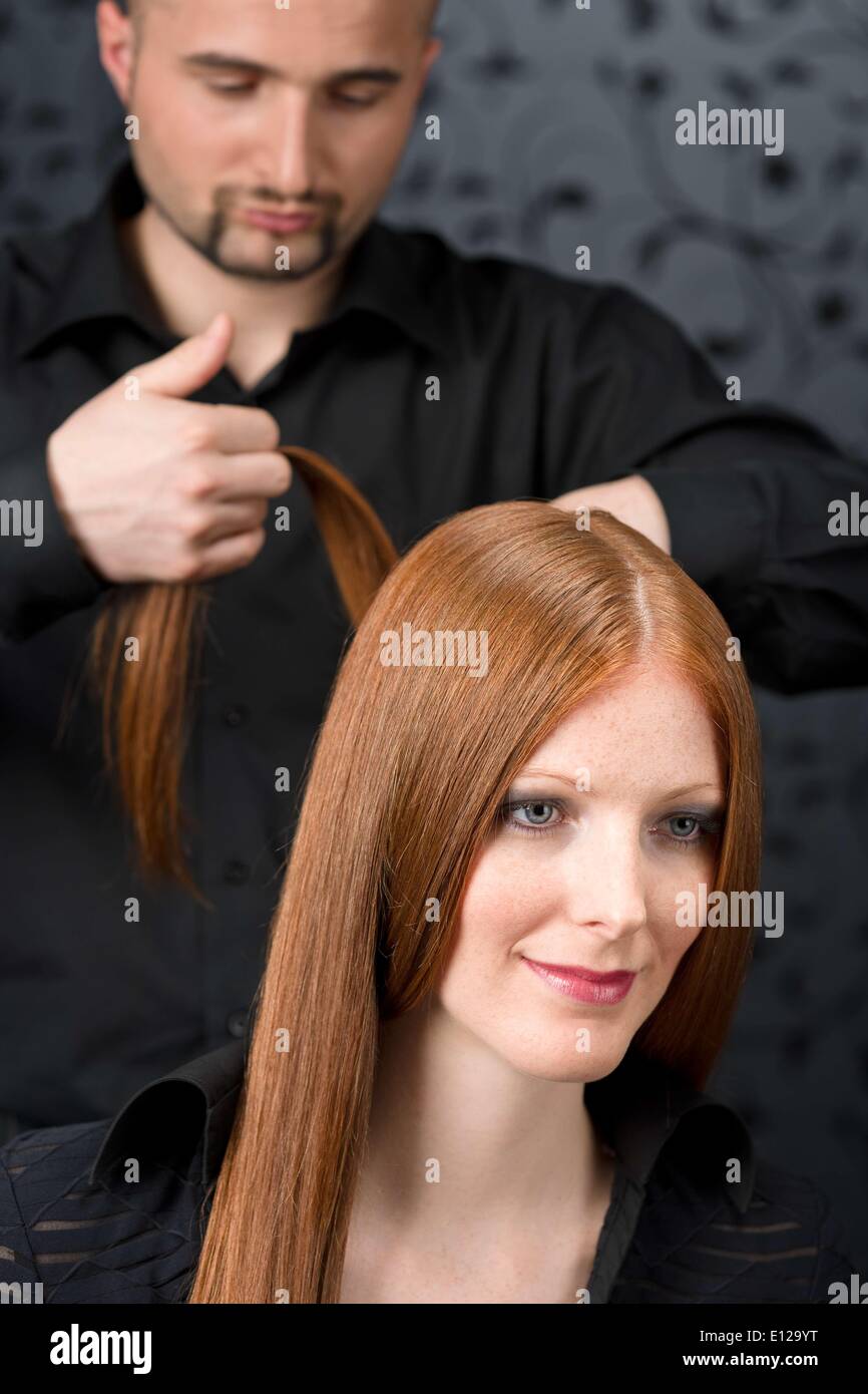 Apr. 07, 2010 - April 7, 2010 - Professional hairdresser with long red hair fashion model at black luxury salon Ã Stock Photo