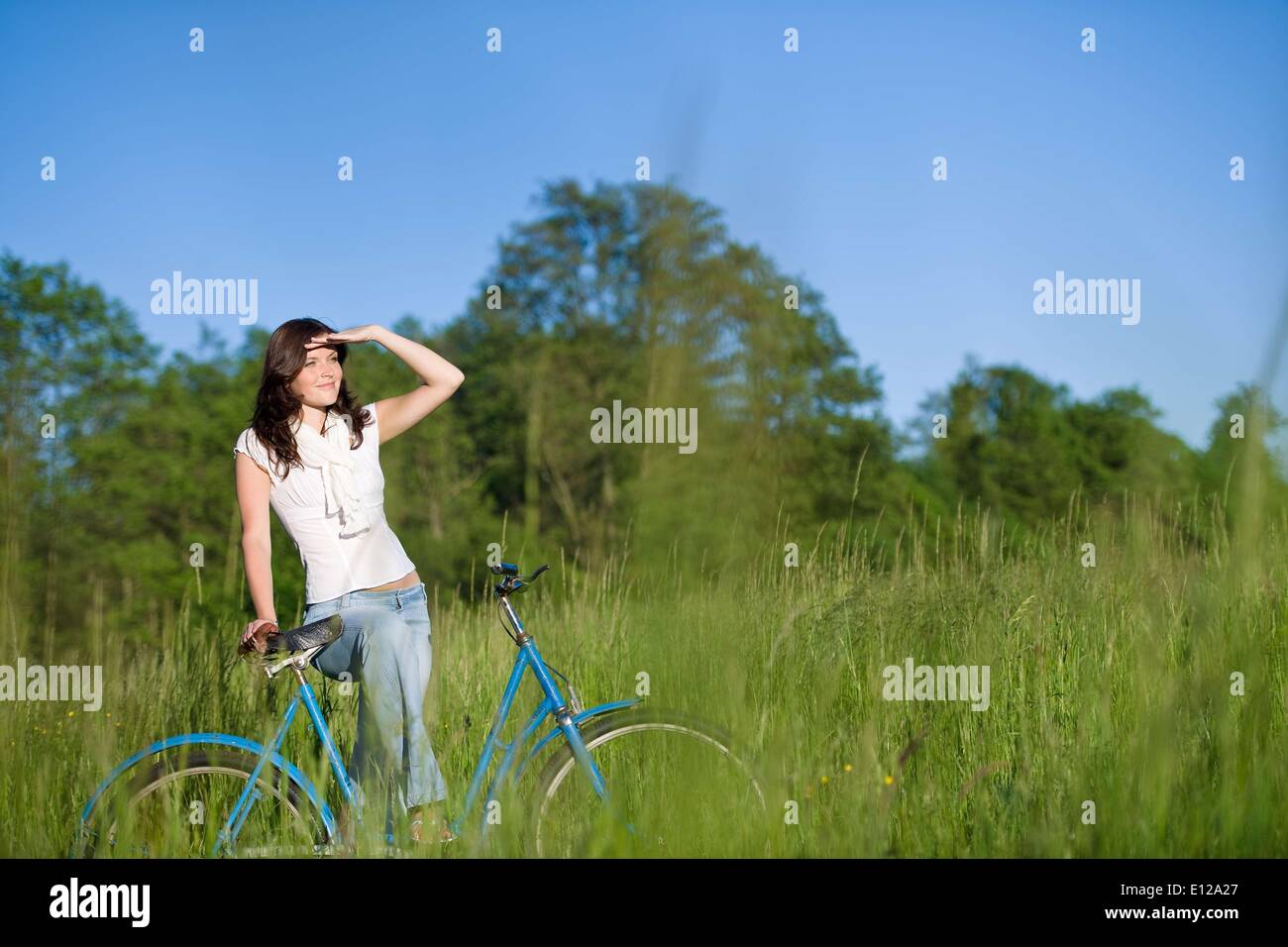 Jun. 05, 2010 - June 5, 2010 - Woman with old-fashioned bike in summer meadow on sunny day Stock Photo