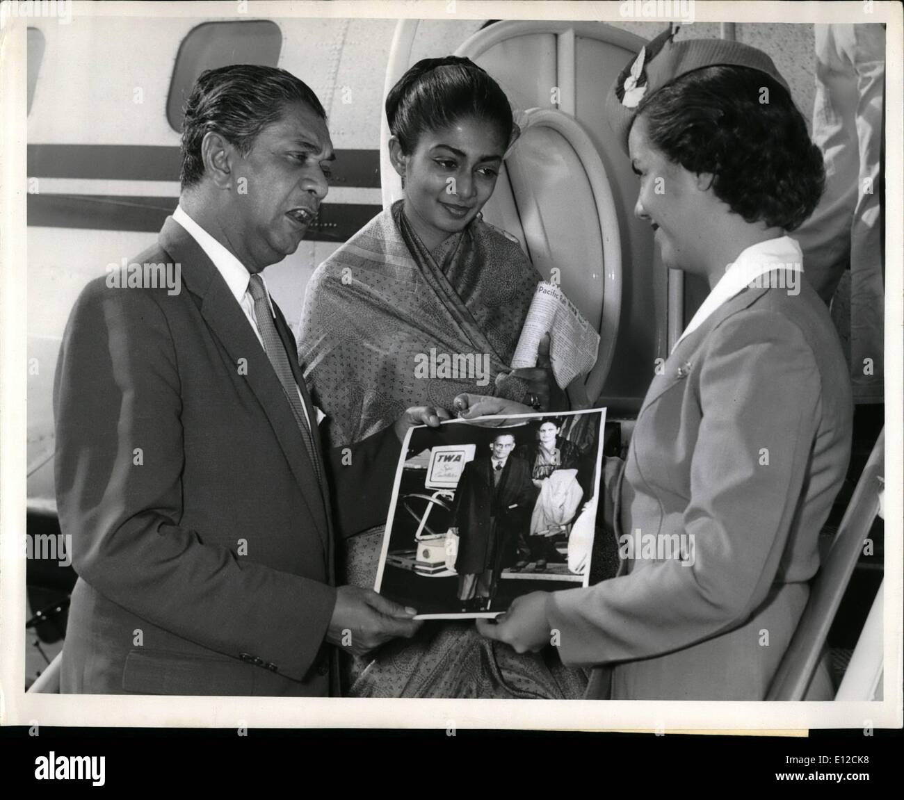 Dec. 12, 2011 - N.Y. international airport, Sept. 26 -- Ceylonese minister of finance, Stanley De zoysa and his daughter, Mrs. Roma jinadasa, both having arrived only yesterday morning from Colombo, are presented with a photograph of the late prime minister of Ceylon, s.w.r.d. bandaranaike (Taken during his last visit to the united states in November, 1956), by TWA hostess Denis luedtke prior to boarding a TWA jetstream back to Colombo. Mr. De zoysa was advised of the prime minister's assassination on arrival yesterday and is restringing to attend the feral cervices on Wednesday. Stock Photo