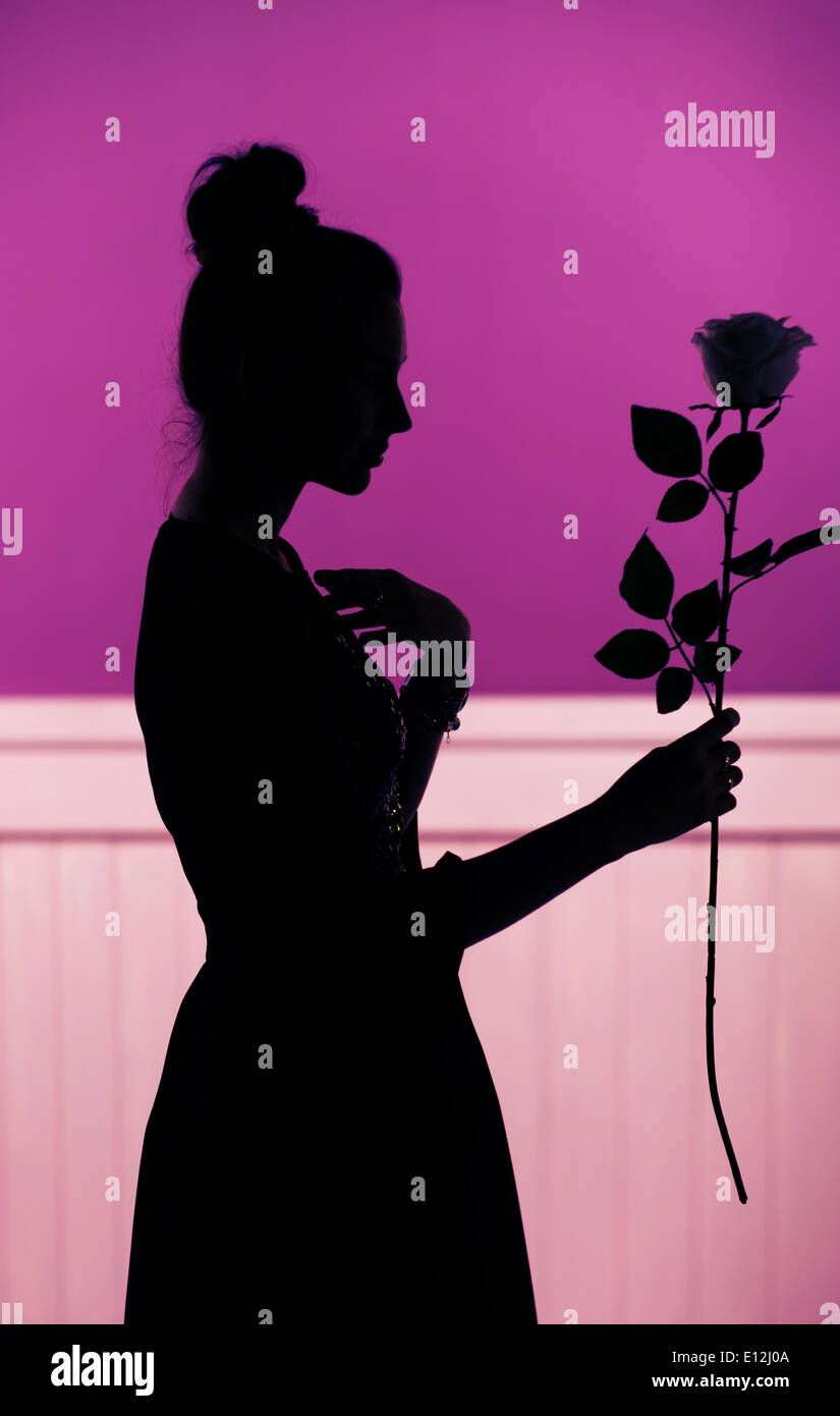 Female silhouette holding the flower Stock Photo