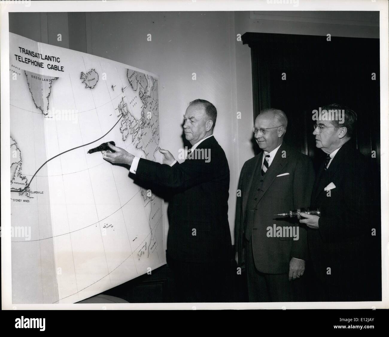 Feb. 24, 2012 - Cleo F. Craig, President, American Tel. & Tel. Co., demonstrate with sample section of route of first intercontinental undersea telephone cable,on which work is now starting. Looking on are H.T. Killingsworth, A.T. & T.. Vice President in charge of Long Lines (center) and W.G.. Thompson, President of Eastern Tel. &Tel. Co., and A.T. &T. subsidiary that will operate new facilities passing through Canada. Stock Photo