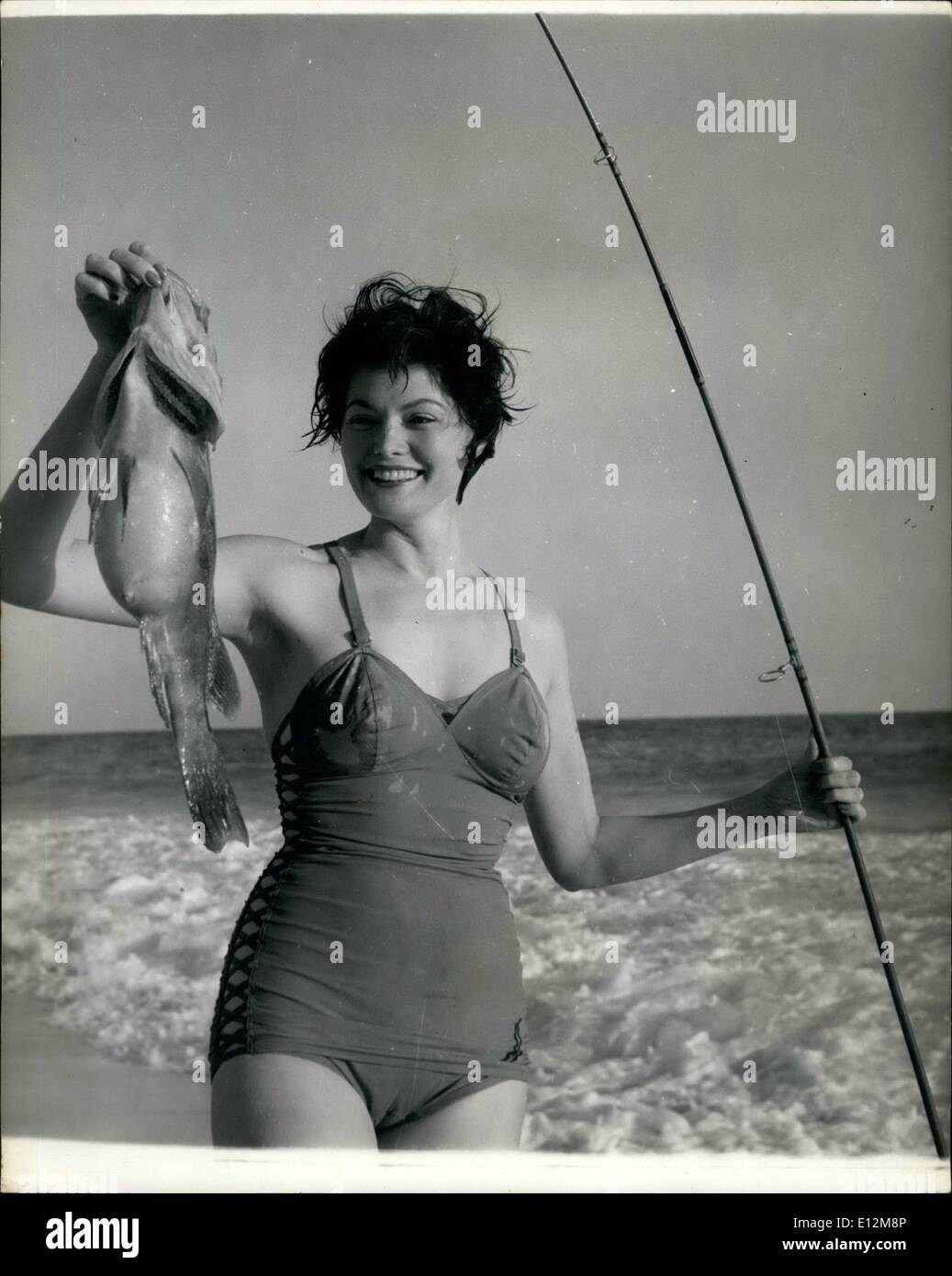 Feb. 24, 2012 - Helen loves surf fishing - and can enjoy her Sport any day in Bermuda's warm and Sunny clime: Often mistaken for Gene Tierney, young Helen Mann often takes time off from her job as a hostess in a Bermuda hotel and gets away from people by making for her favourite lonely beach; There she enjoys a spot of surf fishing for hamlet. Even if she catches nothing, there's the solitude and the surf and spray. Helen hails from Chicago, once was a New York model, and has lived in India and Hong Kong Stock Photo