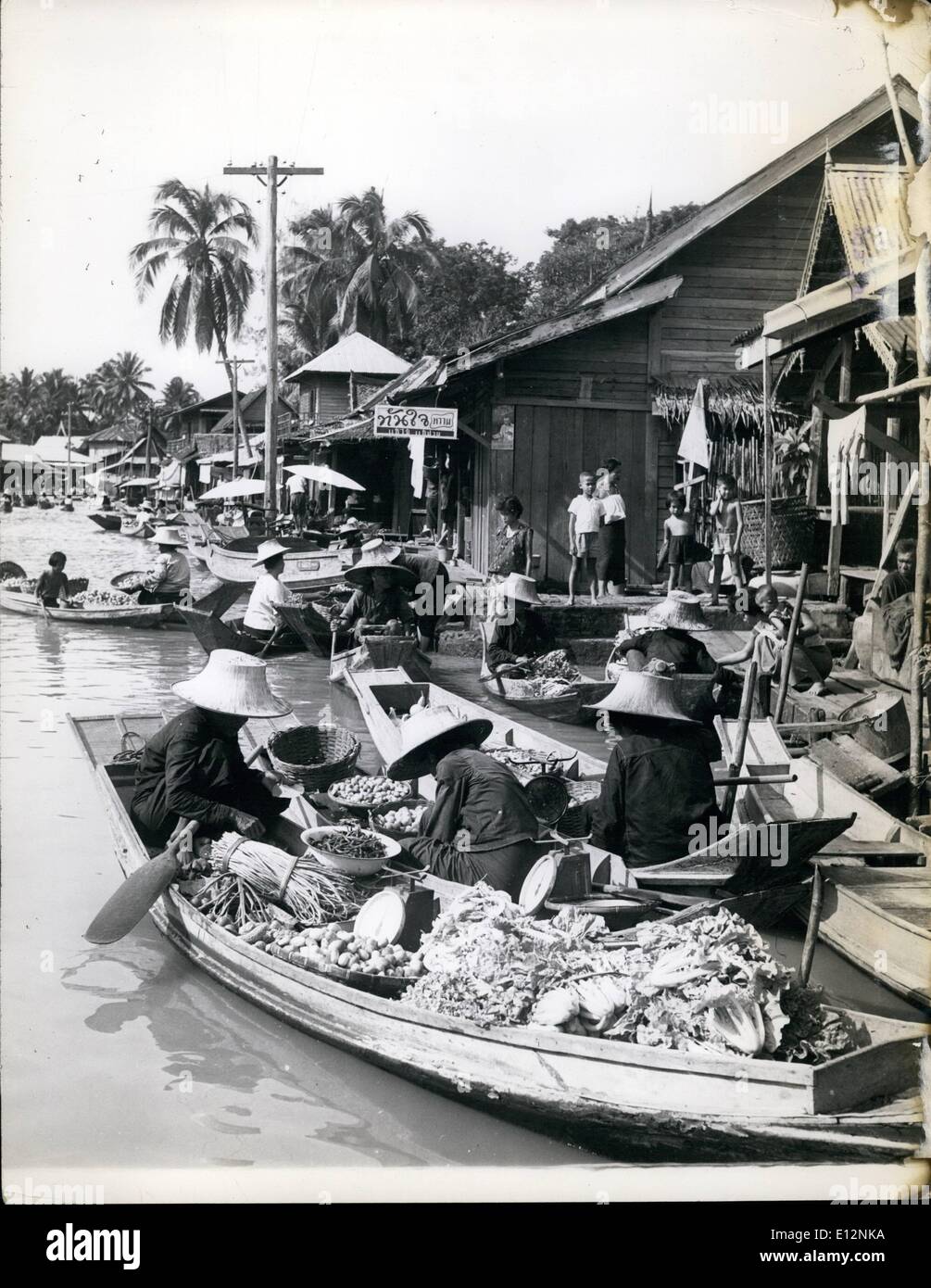 Feb. 24, 2012 - Bangkok-Thailand. Floating fruit and vegetable stalls in the market. All kinds of produce fill the boats also the scales for weighing. Men and women alike wear huge straw hats to protect them from the hot sunshine. Stock Photo