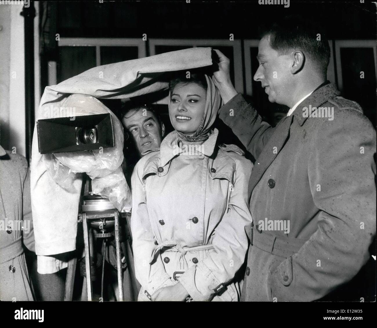 Feb. 25, 2012 - Sophia Loren and Sir Carol Reed wait for the sin to stop and filming to begin in the marketplace at Aylesbury. Sophia Loren As A Foreign Girl In Warthe England: Aylesbury Serves As Location Setting For The Market Of Wartime Naval Town: To wet yet still quaint and historically interesting county market town of Aylesbury, Buckinghamshire, went the entire movie-making team of director Sir Carol Reed and producer-writer Carl Foreman, making ''The Key''. Withe them went the main star of the picture - Italian beauty Sophia Loren Stock Photo