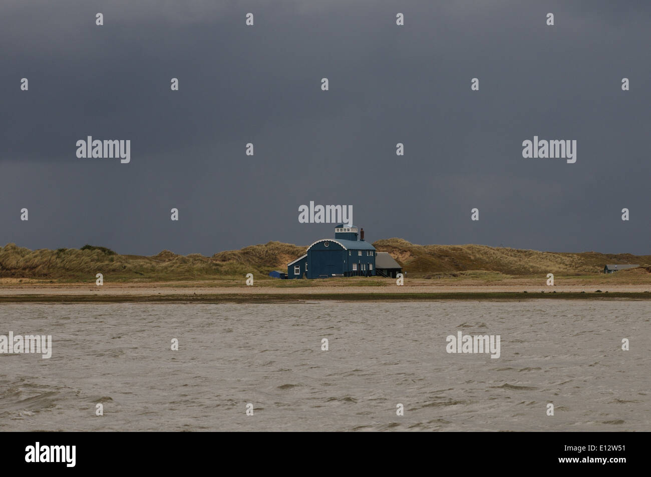 The Old Lifeboat House station and sand dunes on Blakeney Point against a dark sky. Stock Photo