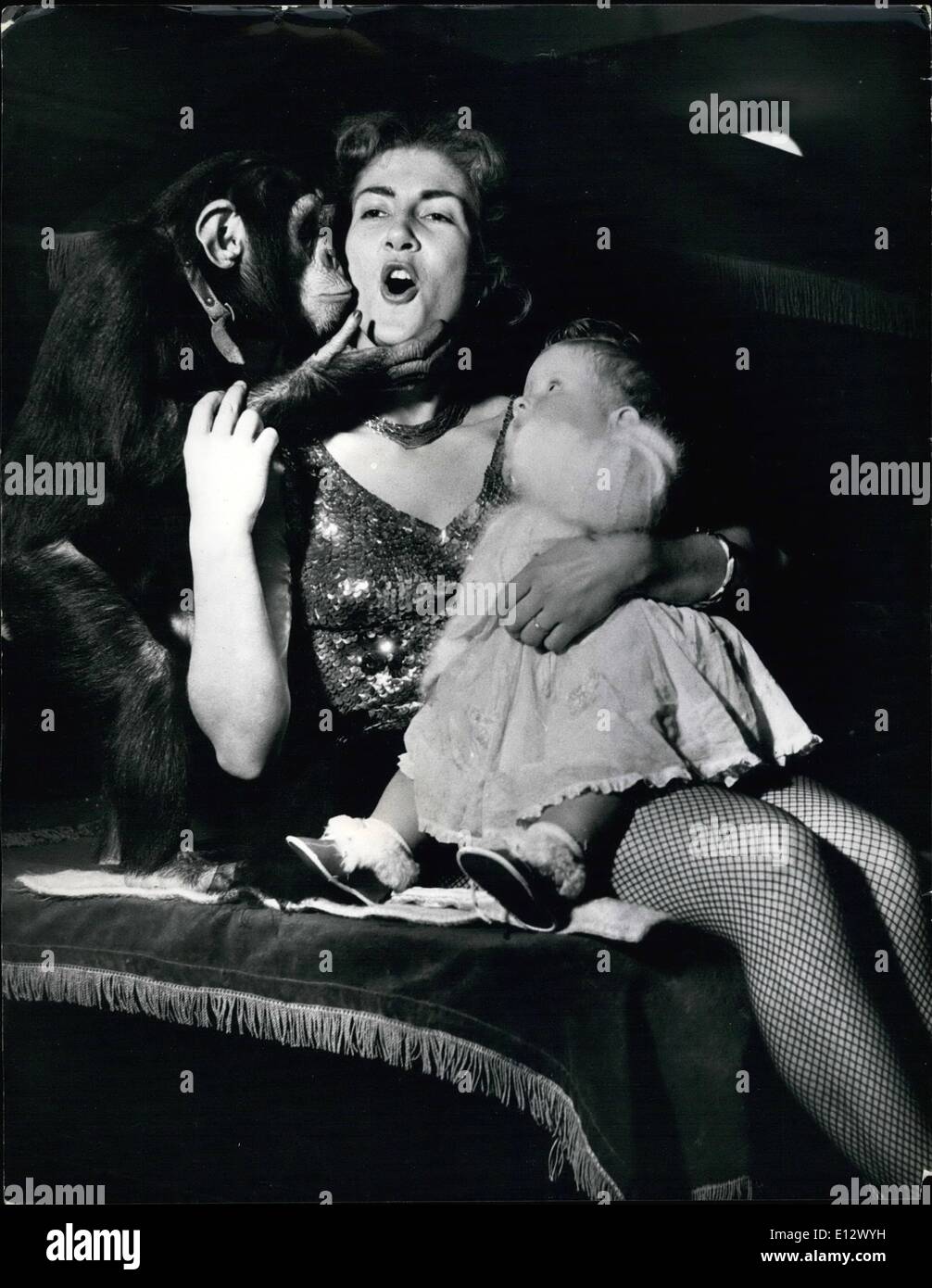 Feb. 25, 2012 - Circus Mother 'Baby Sits' on a Trapeze.: It's always a problem for mothers with jobs to do, to know what to do with their babies during working hours. Mrs. Margaret Stey, daring trapeze artist who is to appear in Jack Hylton's Circus at Earls Court this year, solves the problem by taking her 9-months-old daughter. Randy, with her when she practises on the trapeze high above the sawdust ring. Candy loves watching her other swinging across the ring and its a great thrill for her when mother takes her on the trapeze to give her her bottle of milk Stock Photo