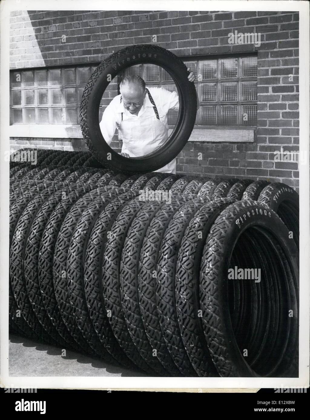 Feb. 26, 2012 - First shipment of old-fashioned tires is on its way from Akron, Ohio, to Washington to meet the needs of the 200 antique automobile owners who will parade down Constitution Avenue September 23 in celebration of the 50th anniversary of the American Automobile Association. Such tires are laboriously made by hand by veteran employees of The Firestone Tire & Rubber Company to duplicate the ones used in the early 1900's. Forty years ago William H. Lincks wrapped the same kind of tires he is shown inspecting above as they were readied for shipment from the Firestone plant in Akron Stock Photo