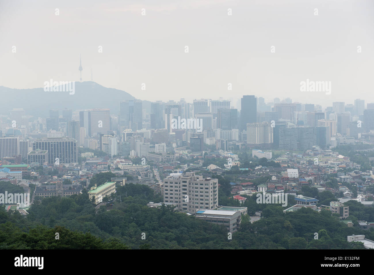 Cityscape of Seoul on a foggy day with skyscrapers and forest Stock Photo