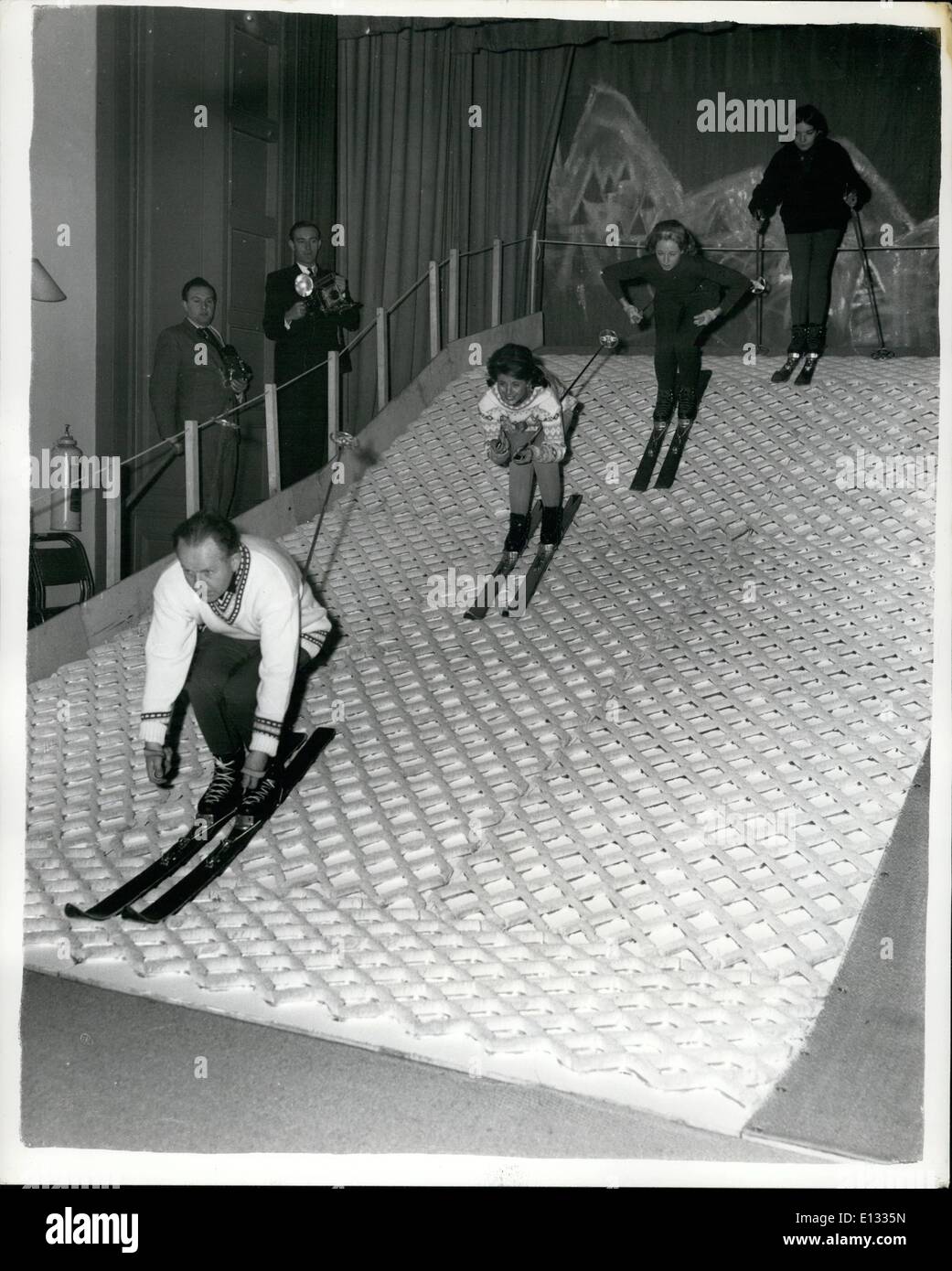 Feb. 26, 2012 - Britain's First Indoor ''Snow Slope'': An Indoor show slope of simulated ''snow'' - (a carpet of fine PVC bristle) - has been constructed by Simpson's of Piccadilly - at the Dry Ski School, Philbeach Hall, Earl's Court. The snow slope will enable beginners to learn the basics of ski-ing without going to a winter resort. Photo shows Four demonstrators - on the new ''snow slope'' this afternoon. They are Left to Right:- Mr. E. Folkman, former Middle East Army Ski Champion; Mlle Stock Photo