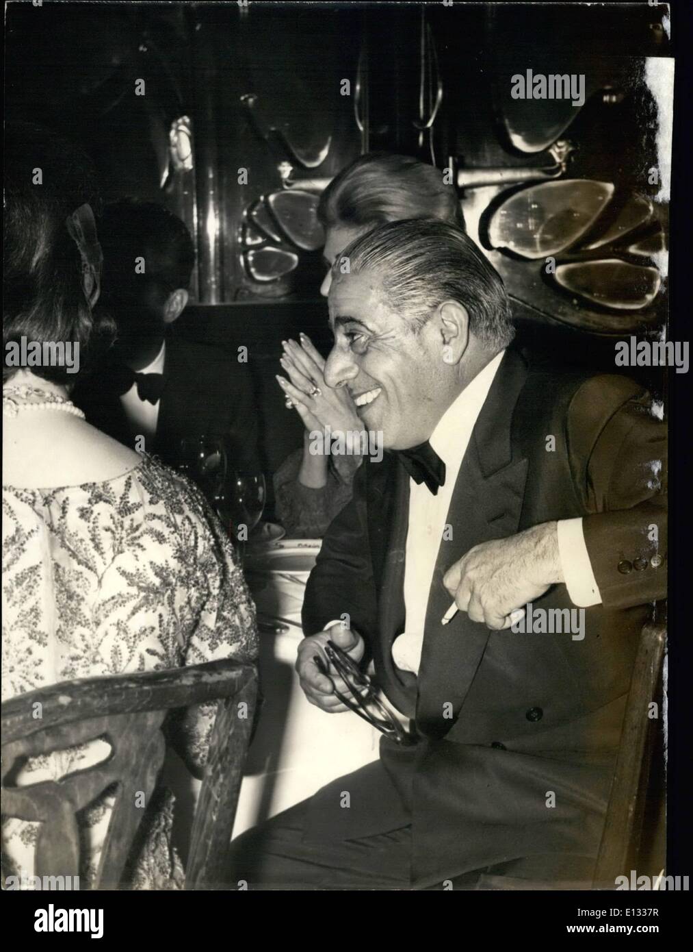 Feb. 26, 2012 - Onassis happy and smiling. OPS: The famous Greek ship owner Aristotle Onassis pictured in a happy mood during the gala dinner held at Maxim's last night. The occasion was the Paris premiere of Anthony Quinn's new film Zorba the Greek . Next to Onassis with back to the camera is Maria la Callas. Stock Photo