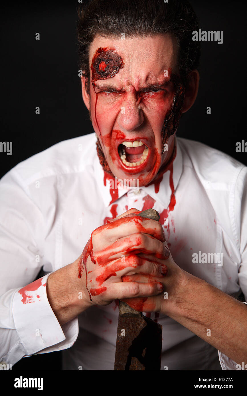 Psychopath with bloody knive in a white shirt Stock Photo