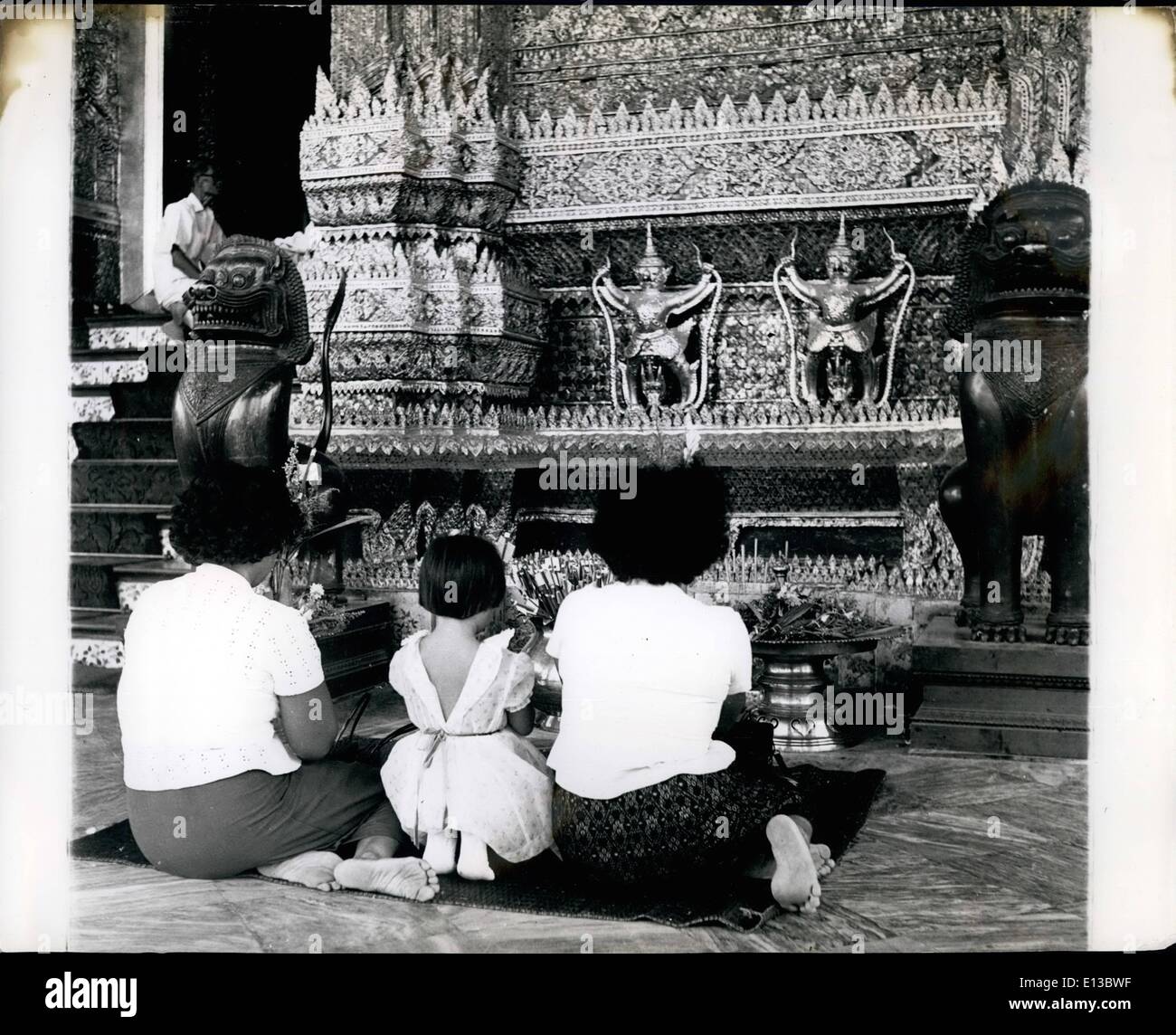Feb. 29, 2012 - On the day on which the public visit the temple the various altars are seldom without worshippers many of them quite young... The Temple Of The Emerald Buddha: Siam's Private Royal Temple Photographed probably for the first time. Most beautiful and fabulous of all the temples in Asia, the Temple of the Emerald Buddha, shrine of the kings of Siam, has seldom if ever before been open for photography. These pictures, just received from our staff correspondent, were taken by special prmission and show something of its majesty and mystery Stock Photo