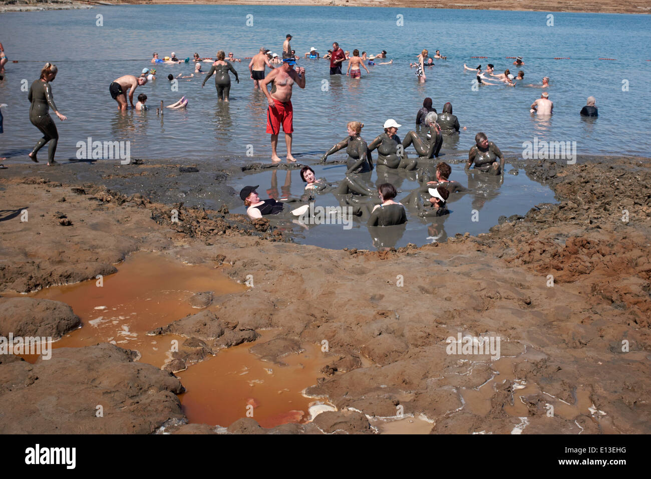 People bathing in the mud in the Dead Sea, Israel Stock Photo