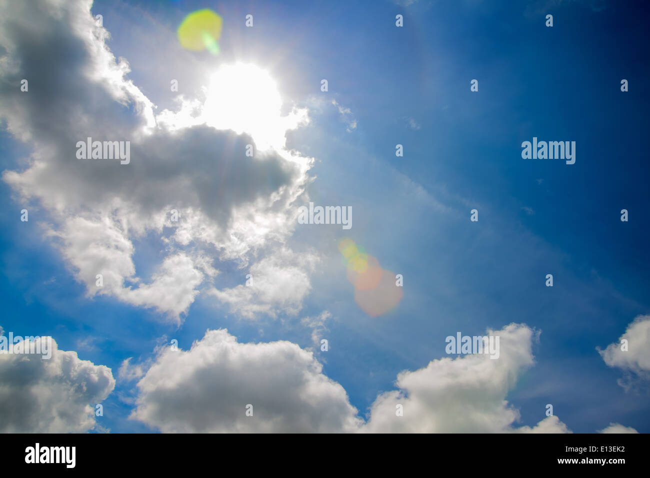 The blue sky with white fluffy clouds and sun Stock Photo - Alamy