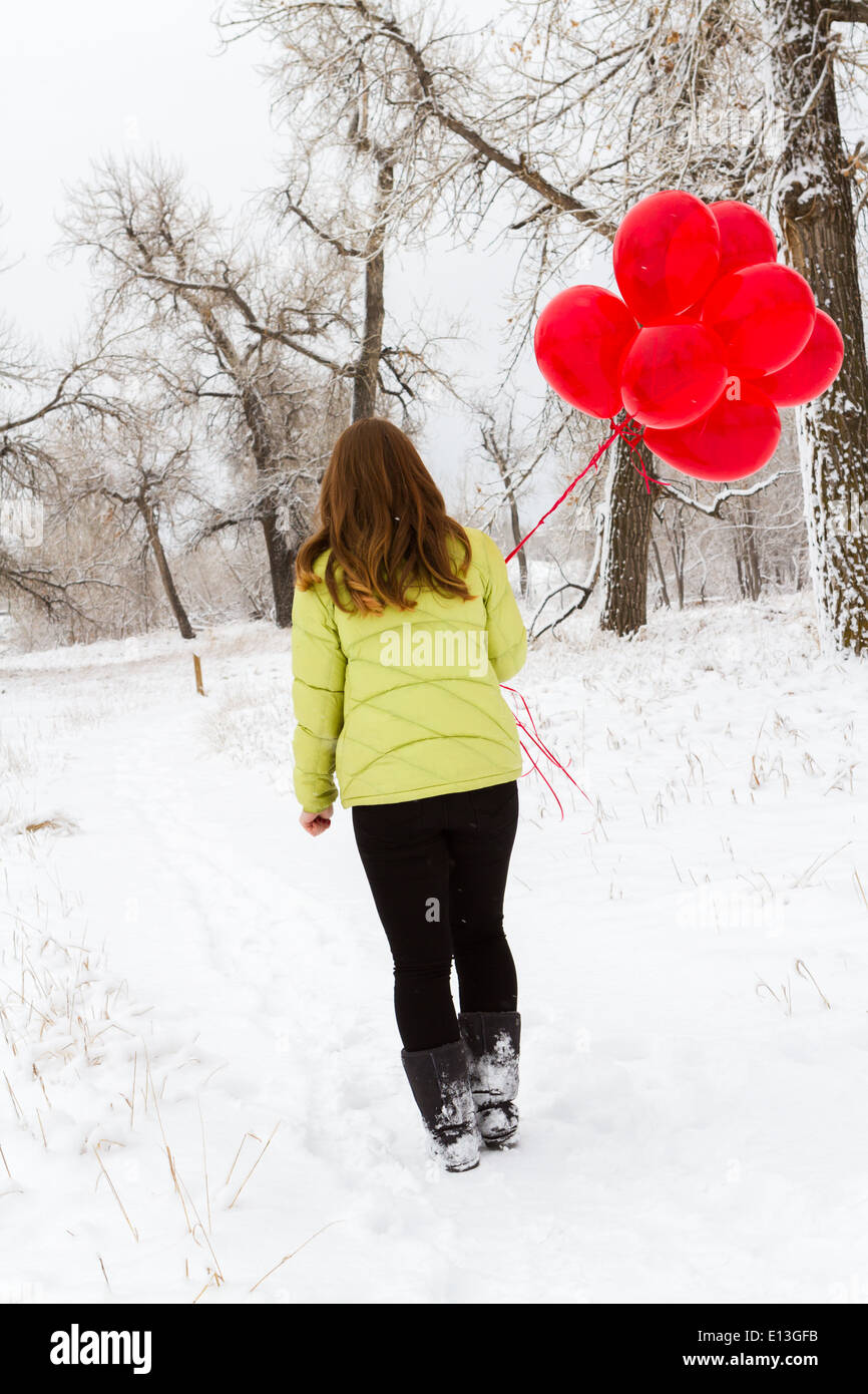 Teenager girl with red balloons walking in the park Stock Photo - Alamy