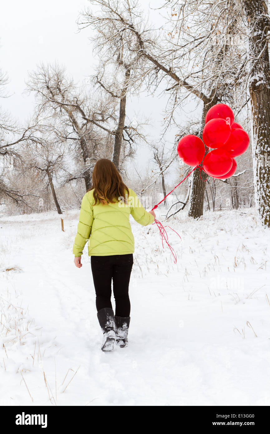 Teenager girl with red balloons walking in the park Stock Photo - Alamy