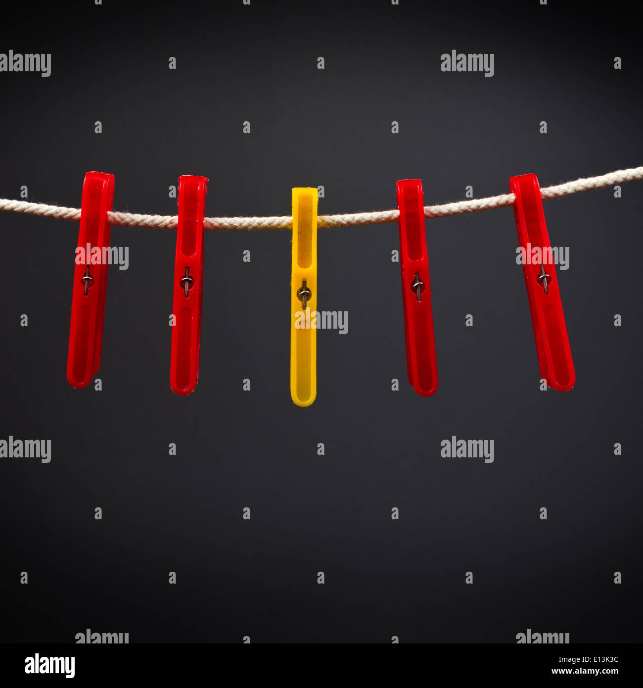 Clothes pins on the rope. Standing out from the crowd. Stock Photo