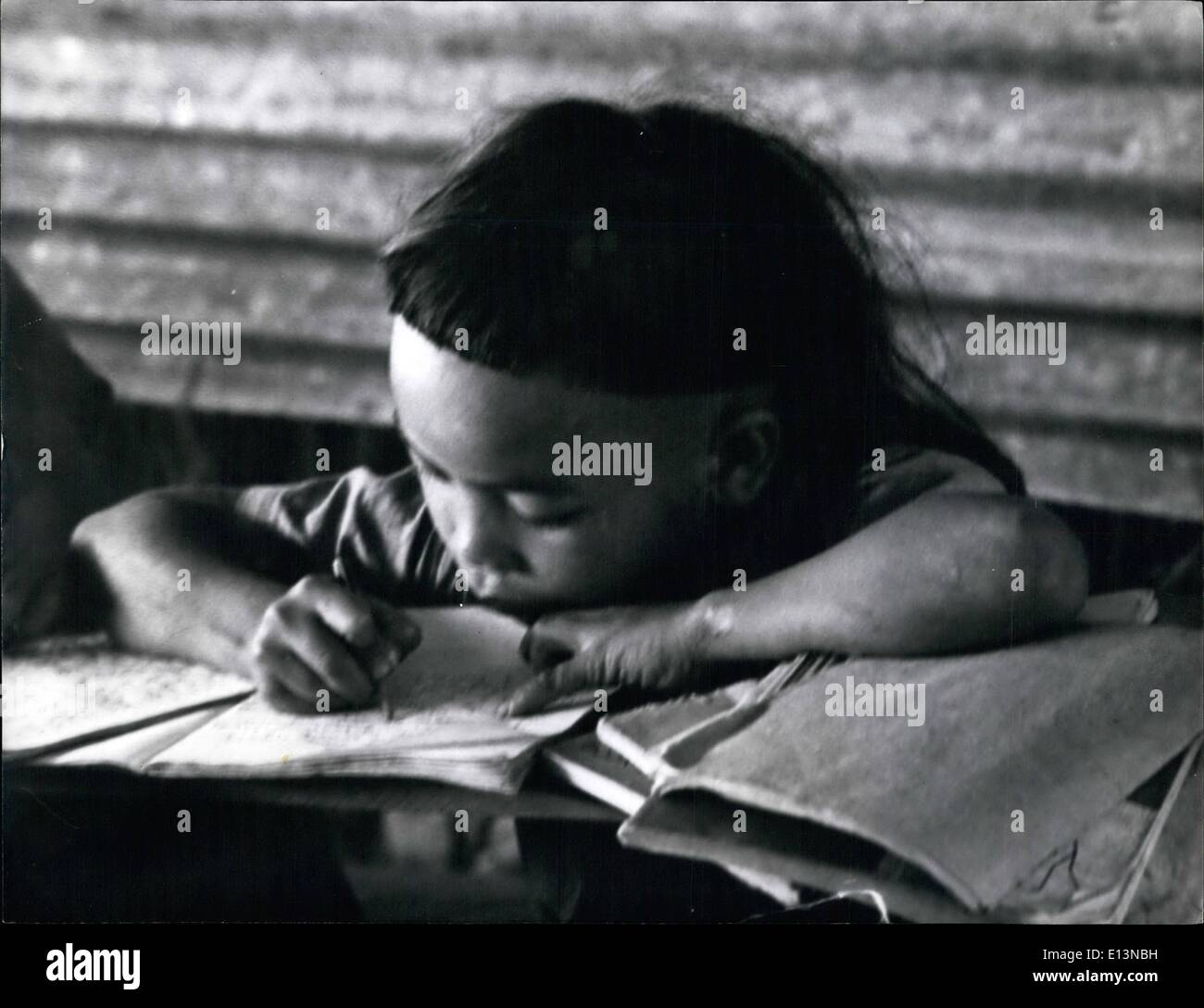 Mar. 02, 2012 - Drooping? Bejewelled Earlobes - And An Ex-Pupil At Ohio State Univ. That's Sarawak's Jungle School: A small girl sits demurely at her desk, her exercise book before her, and in her lap, eyes fixed on her teacher, - just like any other good pupil. But she has a beaded crown on her head, cluster of glittering heavy rings. And the classroom walls are bamboo, the windows air. she is learning English in the jungle school in Brio, the Kelabit Higher Primary School which serves 2,000 square miles of Sarawaka and has 297 pupils Stock Photo