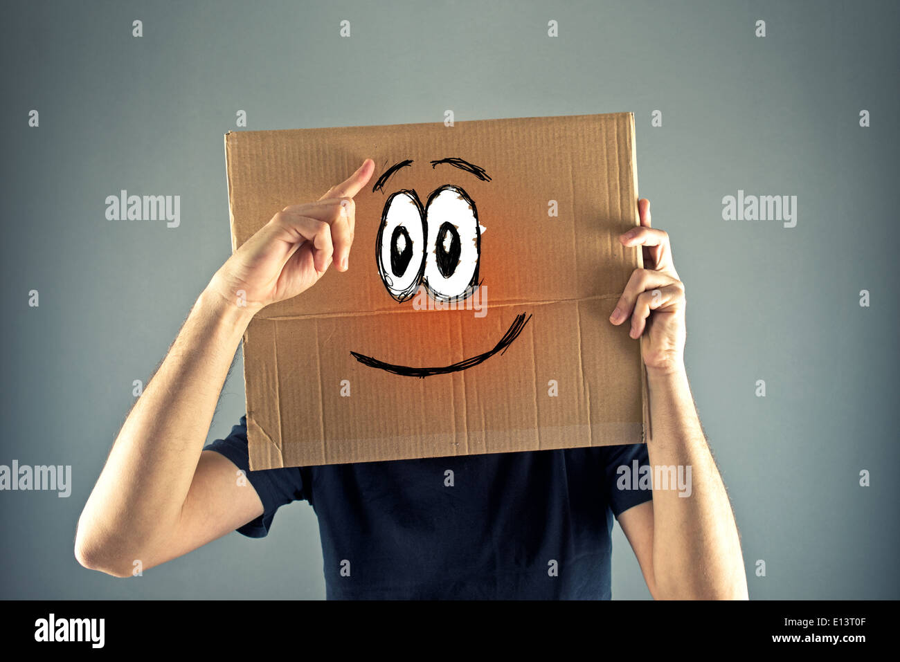 Man with cardboard box on his head with happy face expression just realized something. Stock Photo