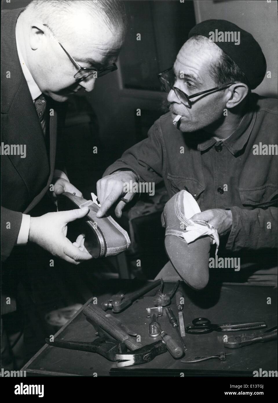Mar. 27, 2012 - Clerical Shoemaker - shows a finished pair to his boss. Stock Photo