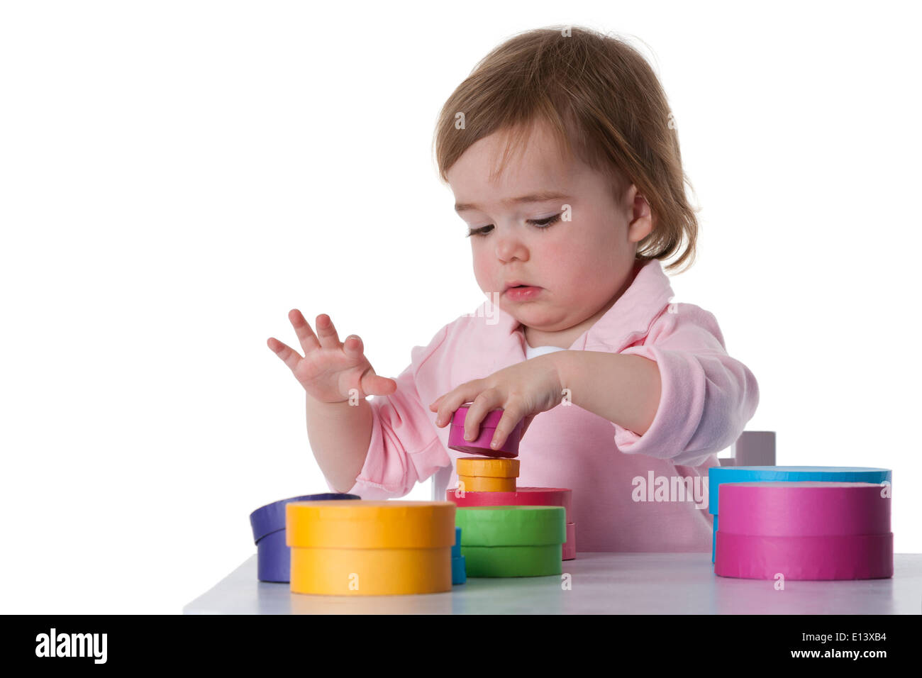 Little girl playing with colored boxes on white background Stock Photo ...
