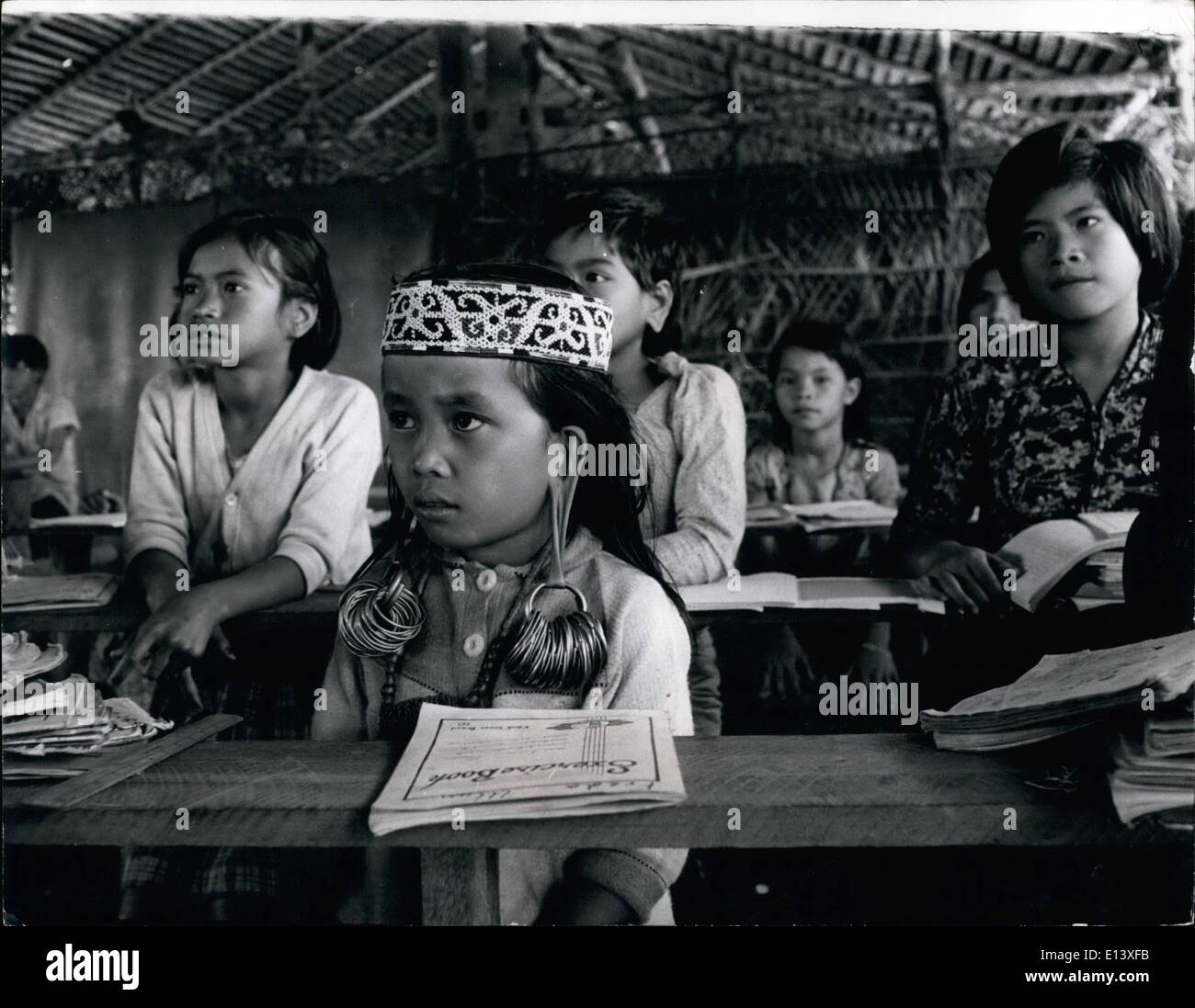 Mar. 27, 2012 - Drooping? Bejewelled Earloses - Aknd Ank Ex-Pupil At Ohio state Univ. That's Sarawak's Jungle school: A small girl sits demurely at her desk, her exercise book before her, hands in her lap, eyes fixed on her teacher just like any other good pupil. But she has a beaded crown on her head and her little ears are weighed down, dropping decorated by a cluster of glittering heavy rings. And the classroom walls are bamboo, the windows air Stock Photo