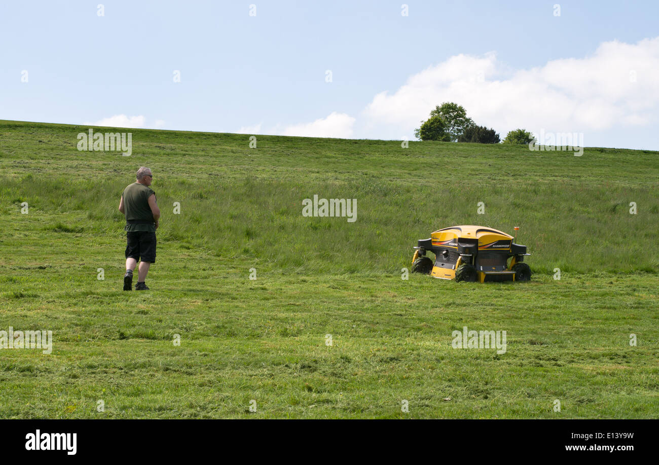 Gardener using a radio controlled Ransomes Spider remote control banks mower Roundhay Park, Leeds, England UK Stock Photo