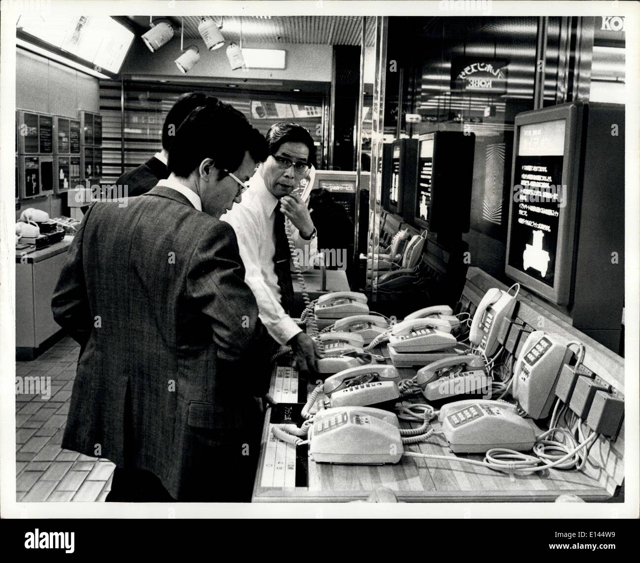 Apr. 04, 2012 - In Japan all telephone equipment is owned by the Individual user. Photo shows in a Japan Telephone Company store a salesmen shows two young Executives varios phones and equipment that are available. In background left are phones and answeing machines. Stock Photo