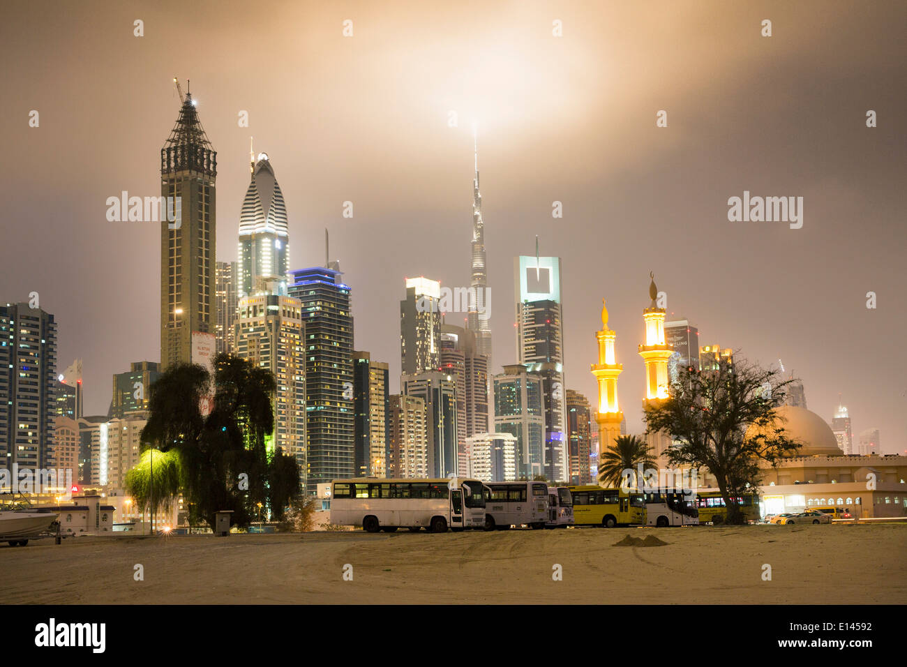 United Arab Emirates, Dubai, Financial city center skyline with Burj Khalifa, highest building in the world. Mosque. Twilight Stock Photo