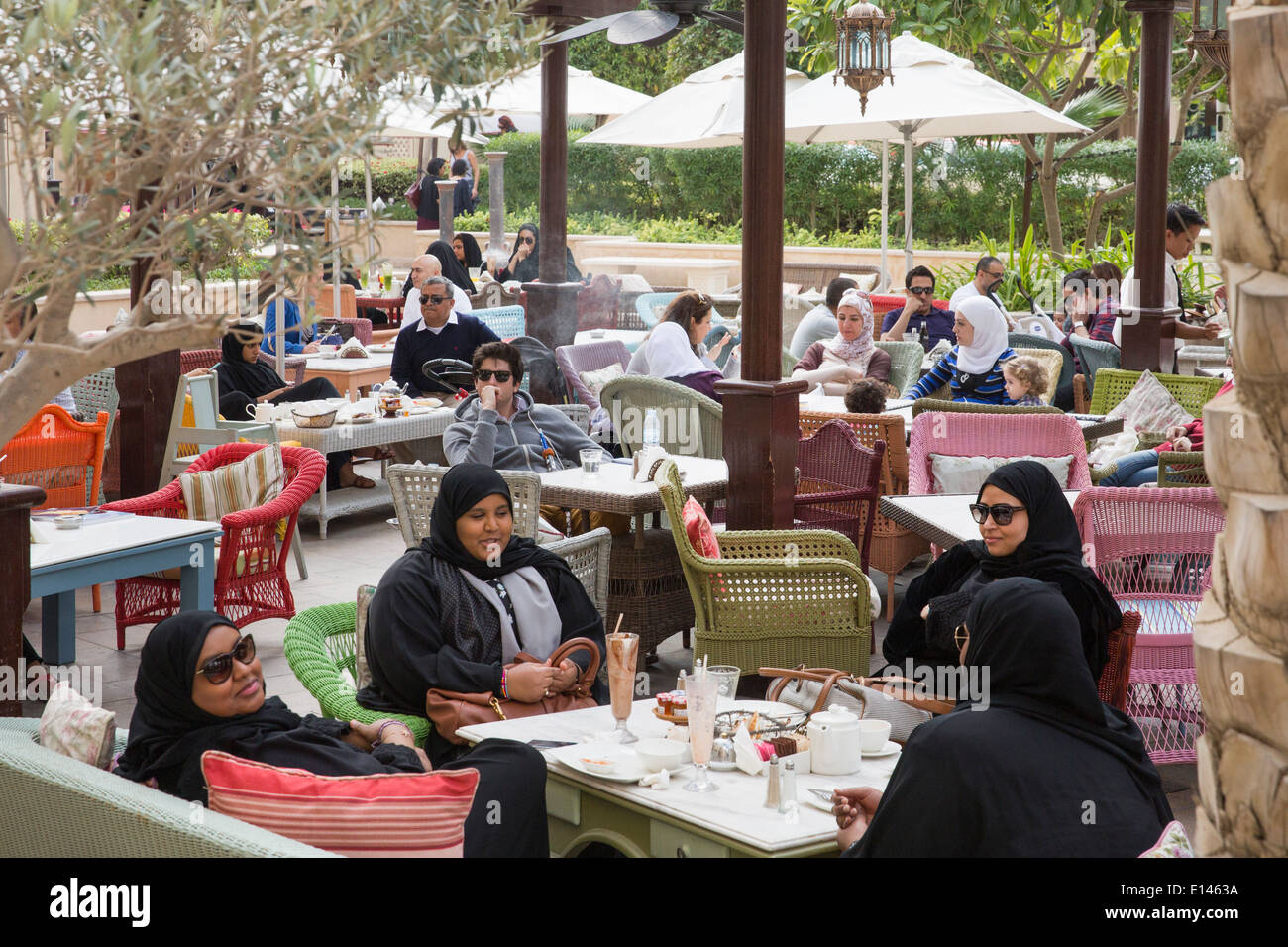 United Arab Emirates, Dubai, Local women chatting on outdoor terrace near Souk Al Bahar Stock Photo