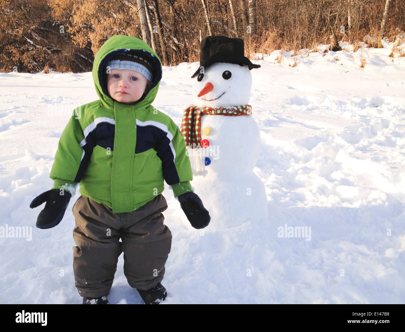 Boy building snowman outdoors - Smartphone Captured Stock Image