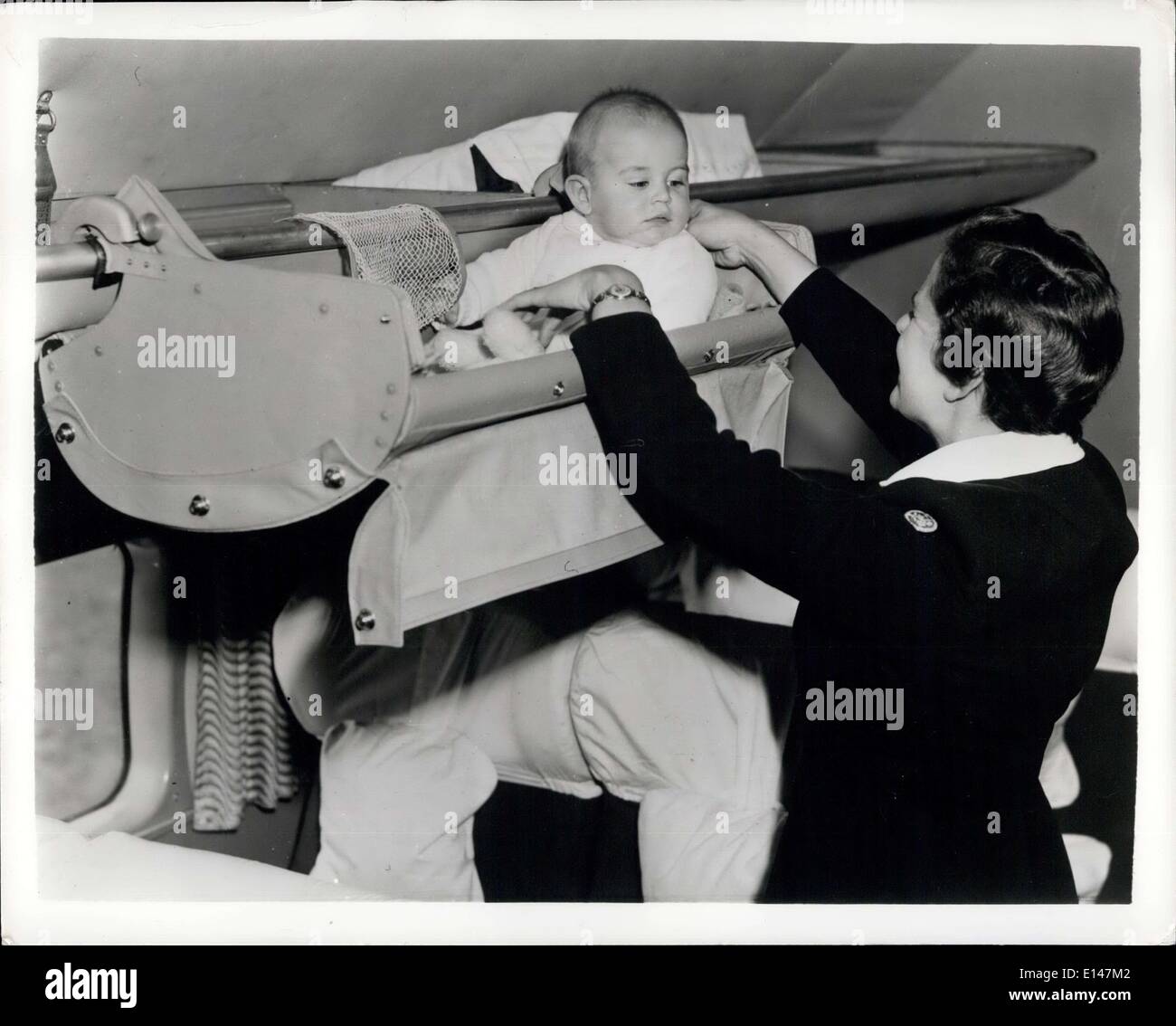 Apr. 17, 2012 - Babies Now Really Sleep in the Clouds: Baby- and mother - can travel in comfort with this ''Sky-Cot'' designed by British Overseas Airways Corporation. It clips onto the overhead lugagge rack of the plane. It is claimed strongly built, and that even the most restless baby cannot fall out. Photo shows Stewardess tucks baby in the ''Sky-Cot'' made by Whitgam Bennett LTD., 43-45 Thames St. Kingston - on Thames, Surrey, England. Stock Photo